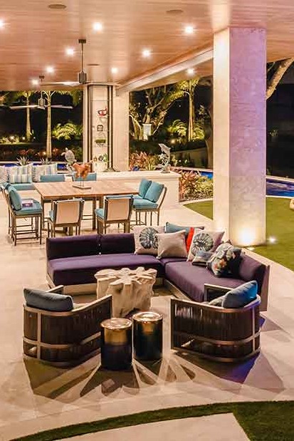 Custom patio space with modern seating, dining area, and nighttime landscape lighting