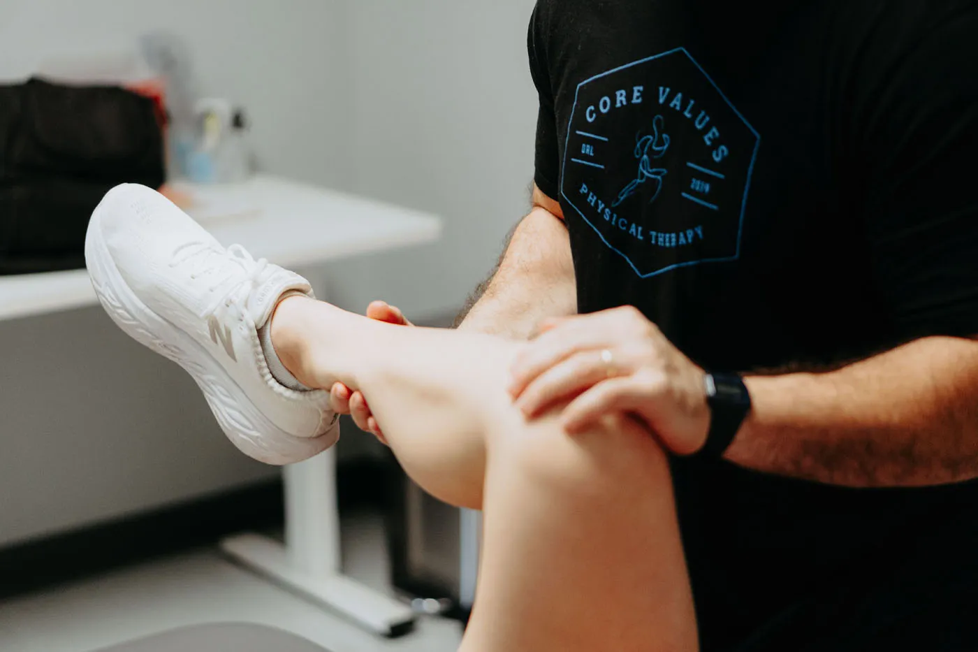 Physical therapist performing an ankle assessment on a patient