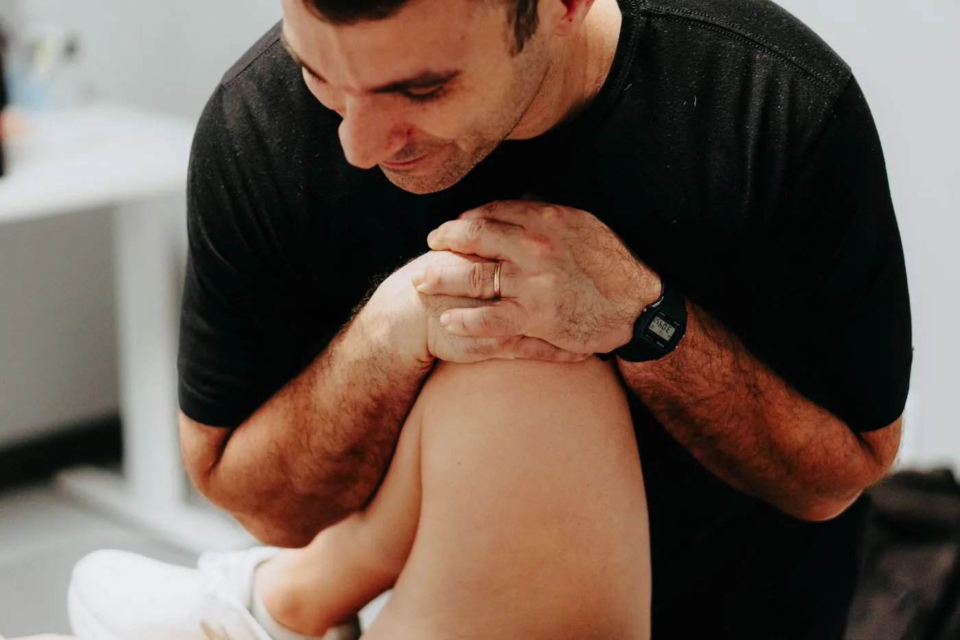 Physical therapist using a fist technique for knee manual therapy