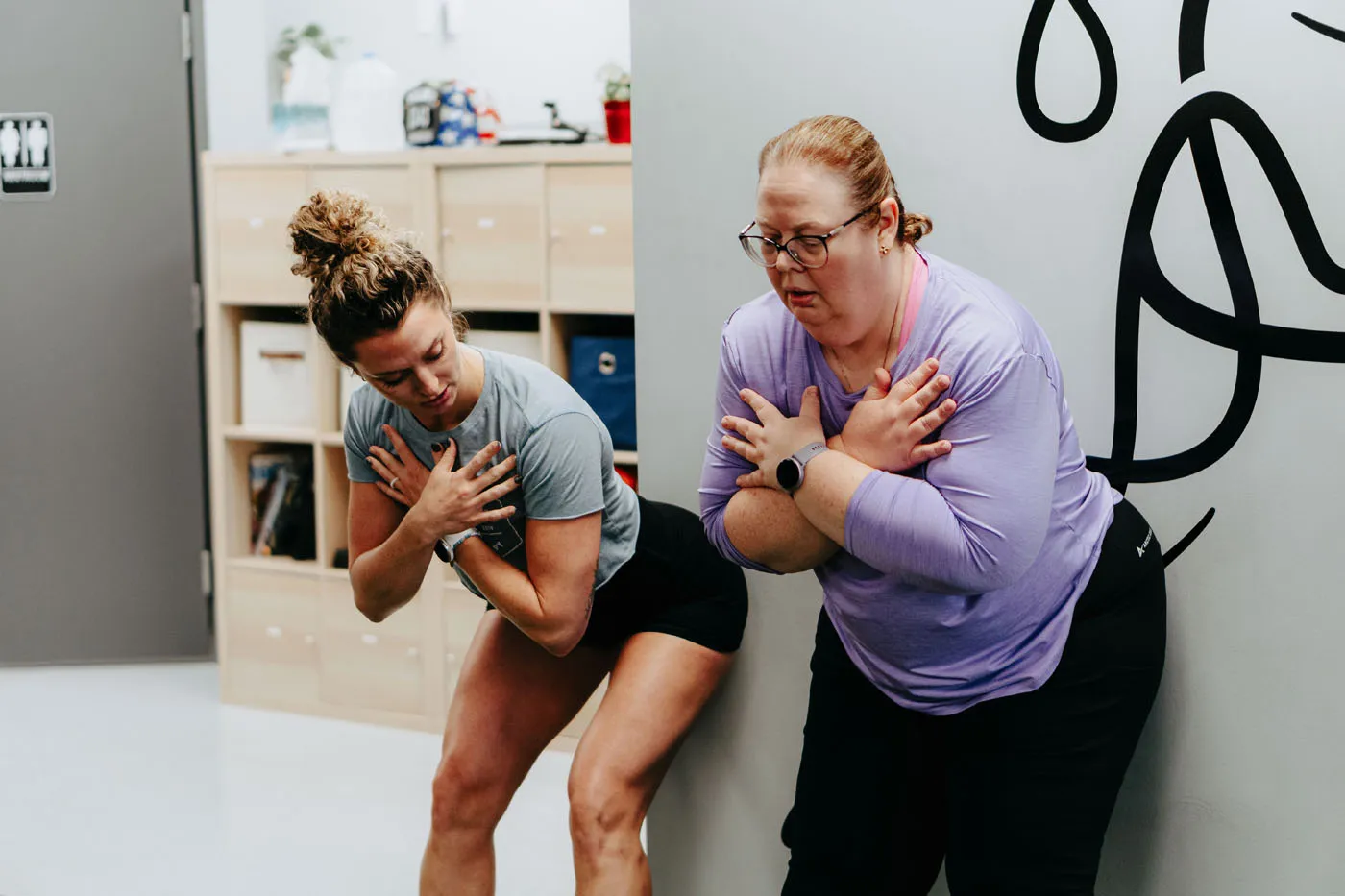 Physical therapist demonstrating a chest exercise with a patient