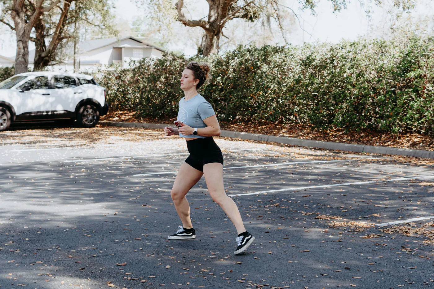 Physical therapist demonstrating running form in the clinic parking lot