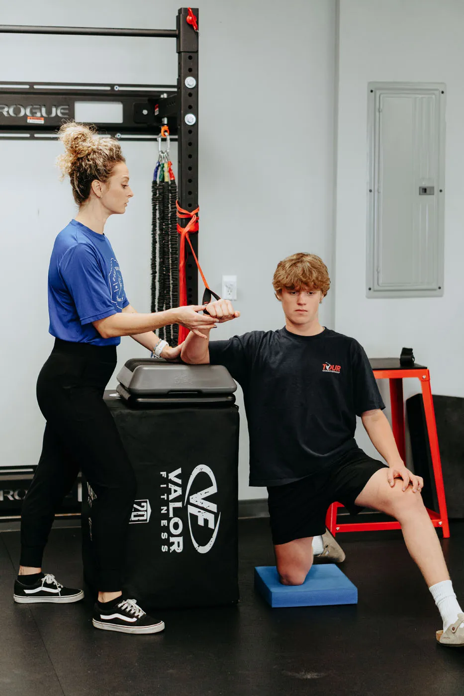 Physical therapist guiding a teen patient through a resistance exercise