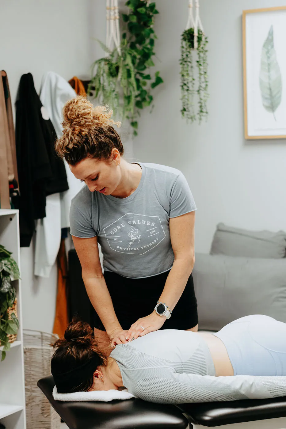 Physical therapist performing upper back manual therapy on a prone patient