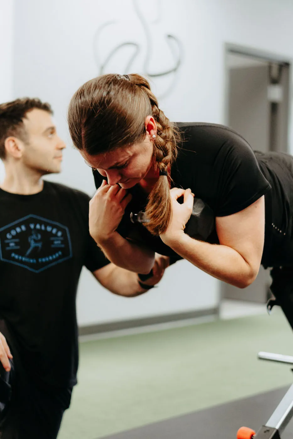 Physical therapist performing spinal manual therapy on a patient at the bench