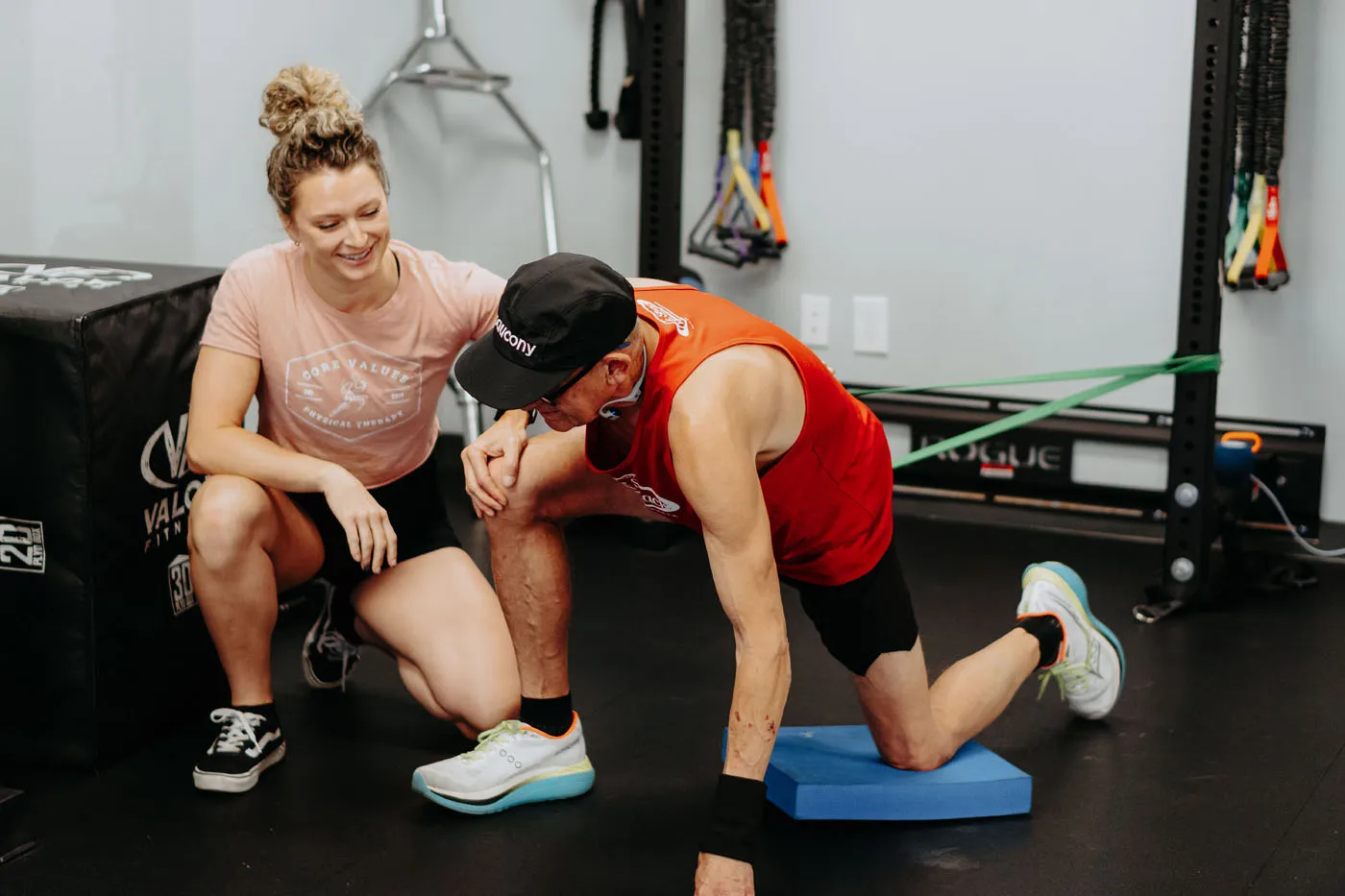 Patient balancing on a balance pad supervised by a physical therapist