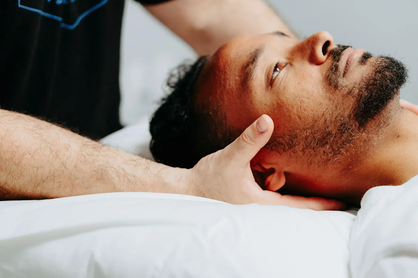 Physical therapist performing cervical manual therapy on a supine patient