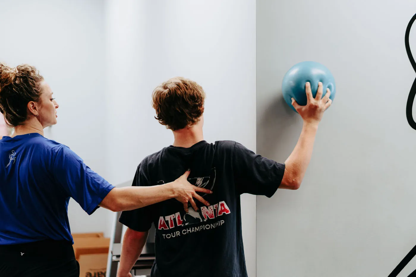 Patient pressing a medicine ball against the wall for a shoulder exercise