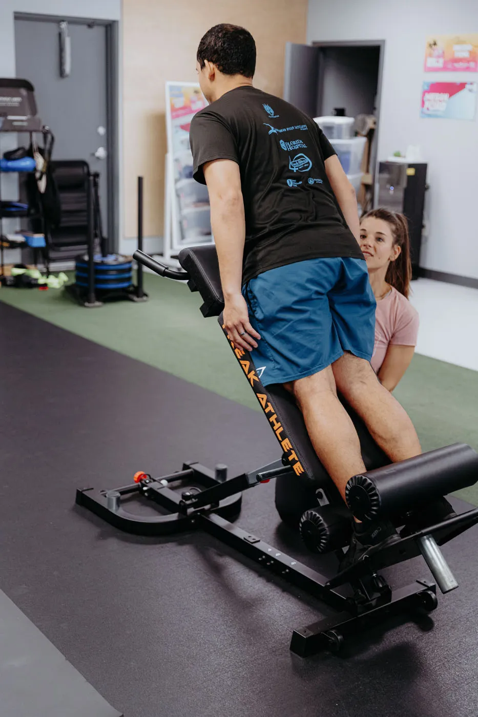 Patient performing Nordic curls on a Freak Athlete bench with a physical therapist