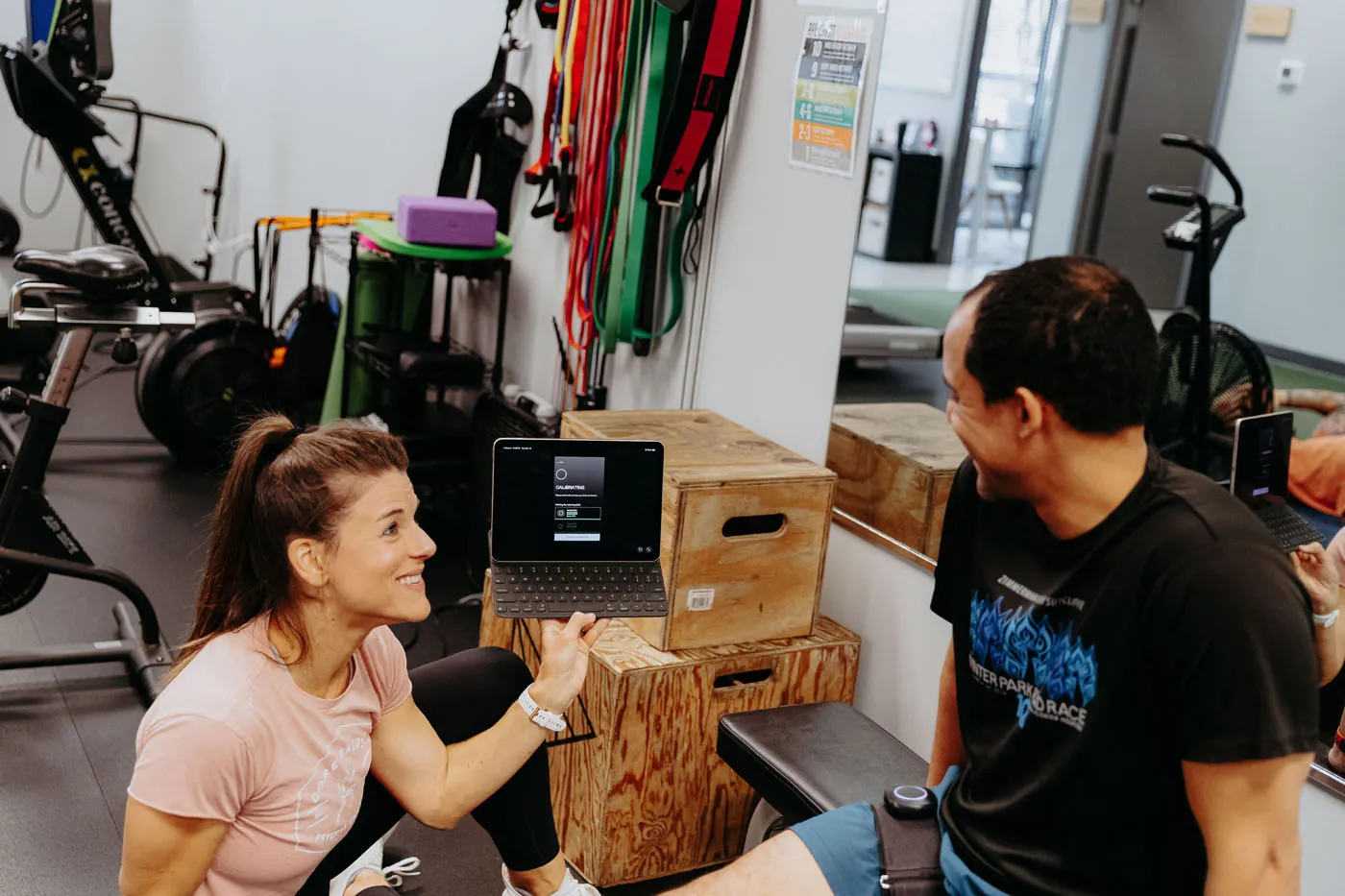 Patient smiling with a motion sensor attached during a physical therapy session