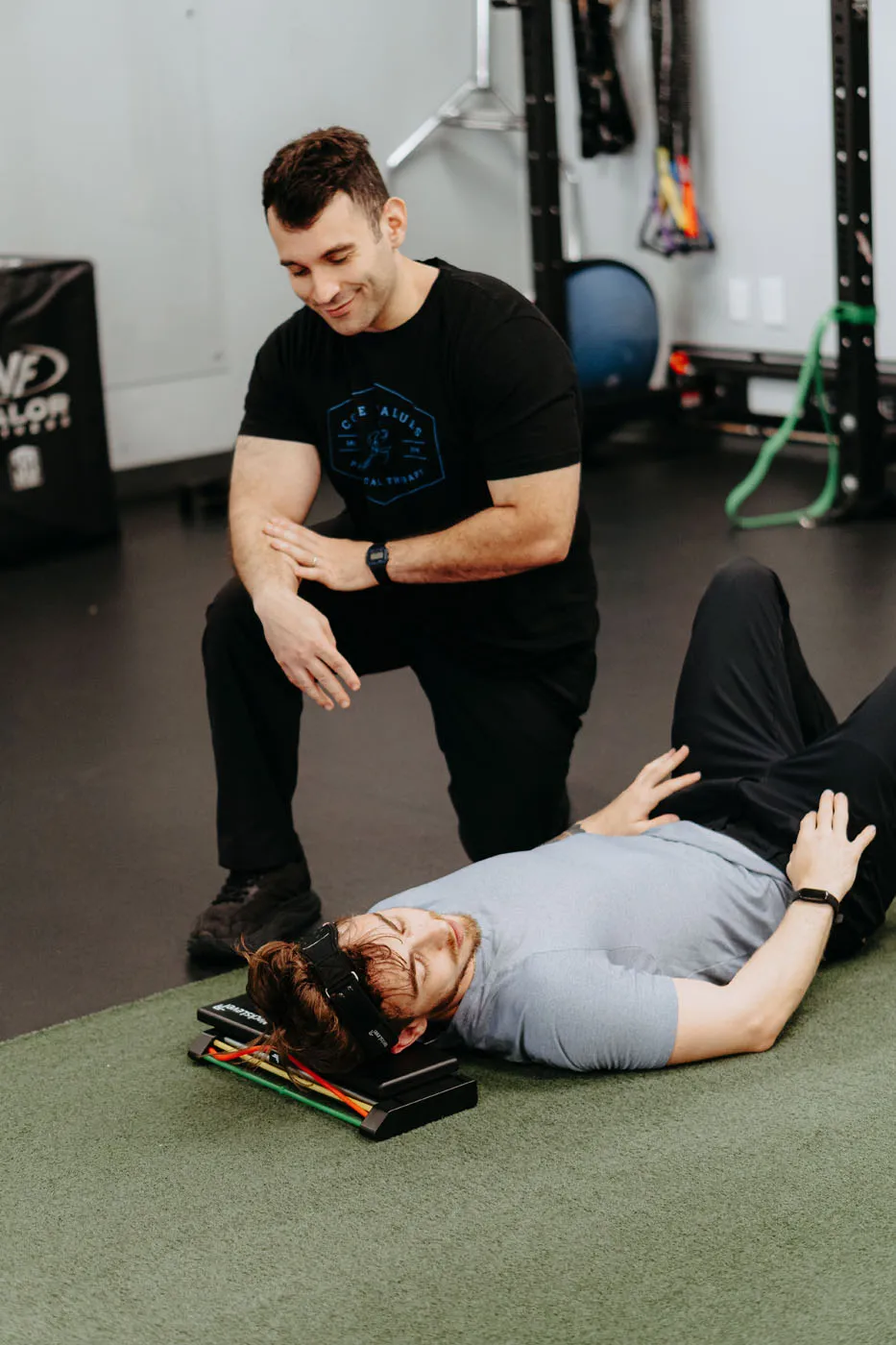 Patient using a NecksLevel device on the floor for cervical rehabilitation