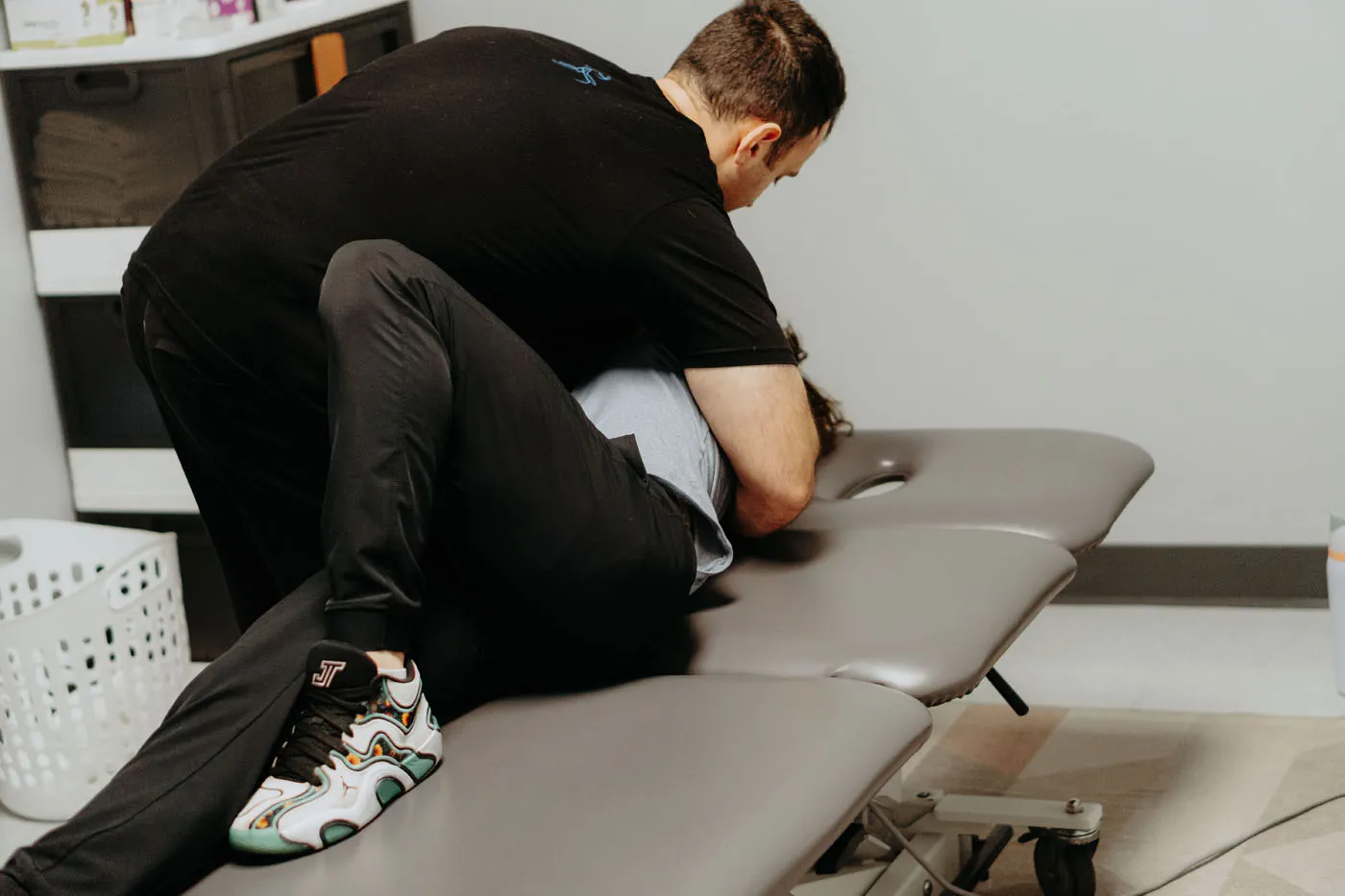 Physical therapist performing HVLA thoracic manipulation on a treatment table