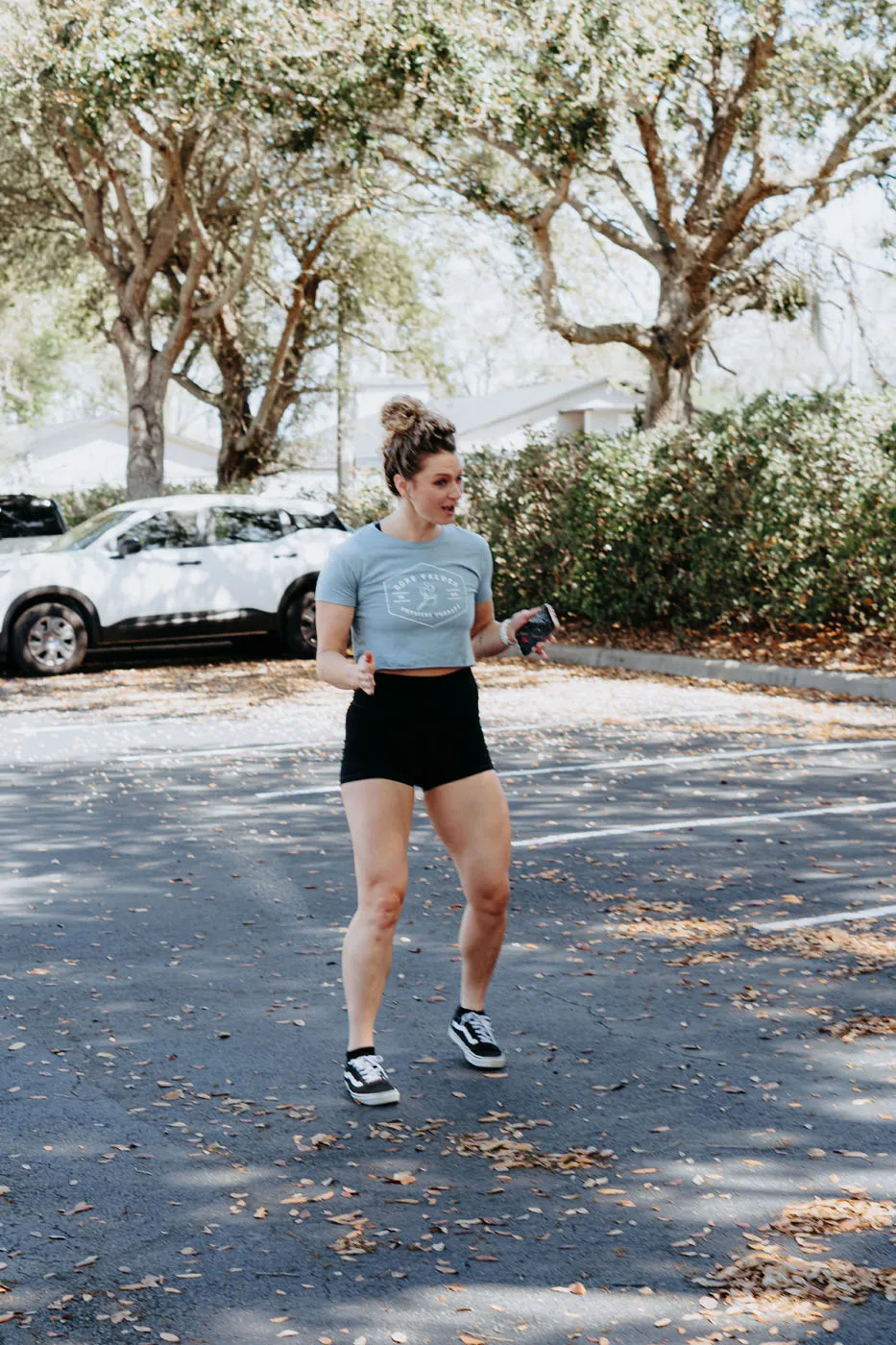 Physical therapist demonstrating running form outdoors near the clinic