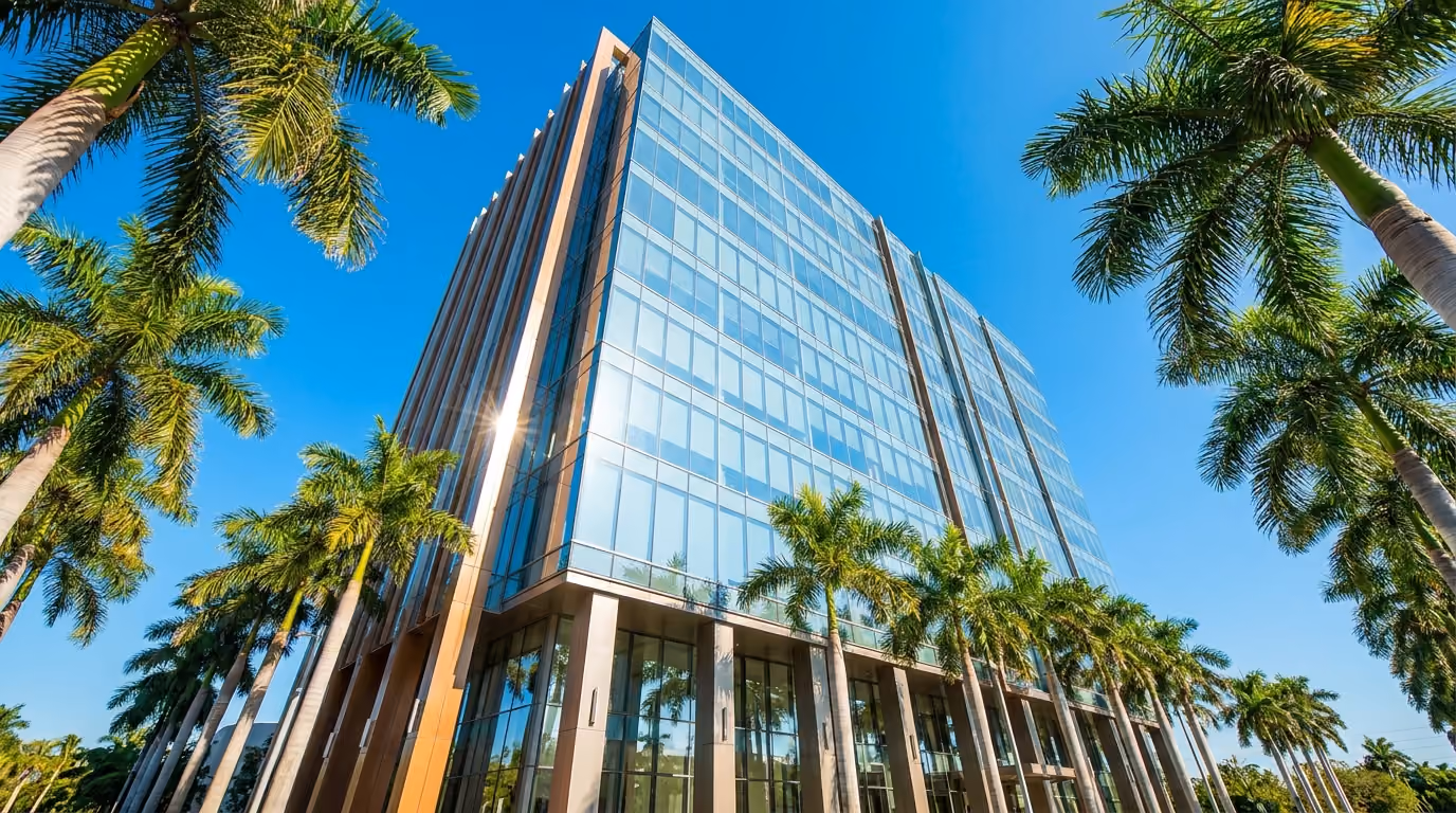 Edifício corporativo de vidro com palmeiras sob céu azul na Flórida