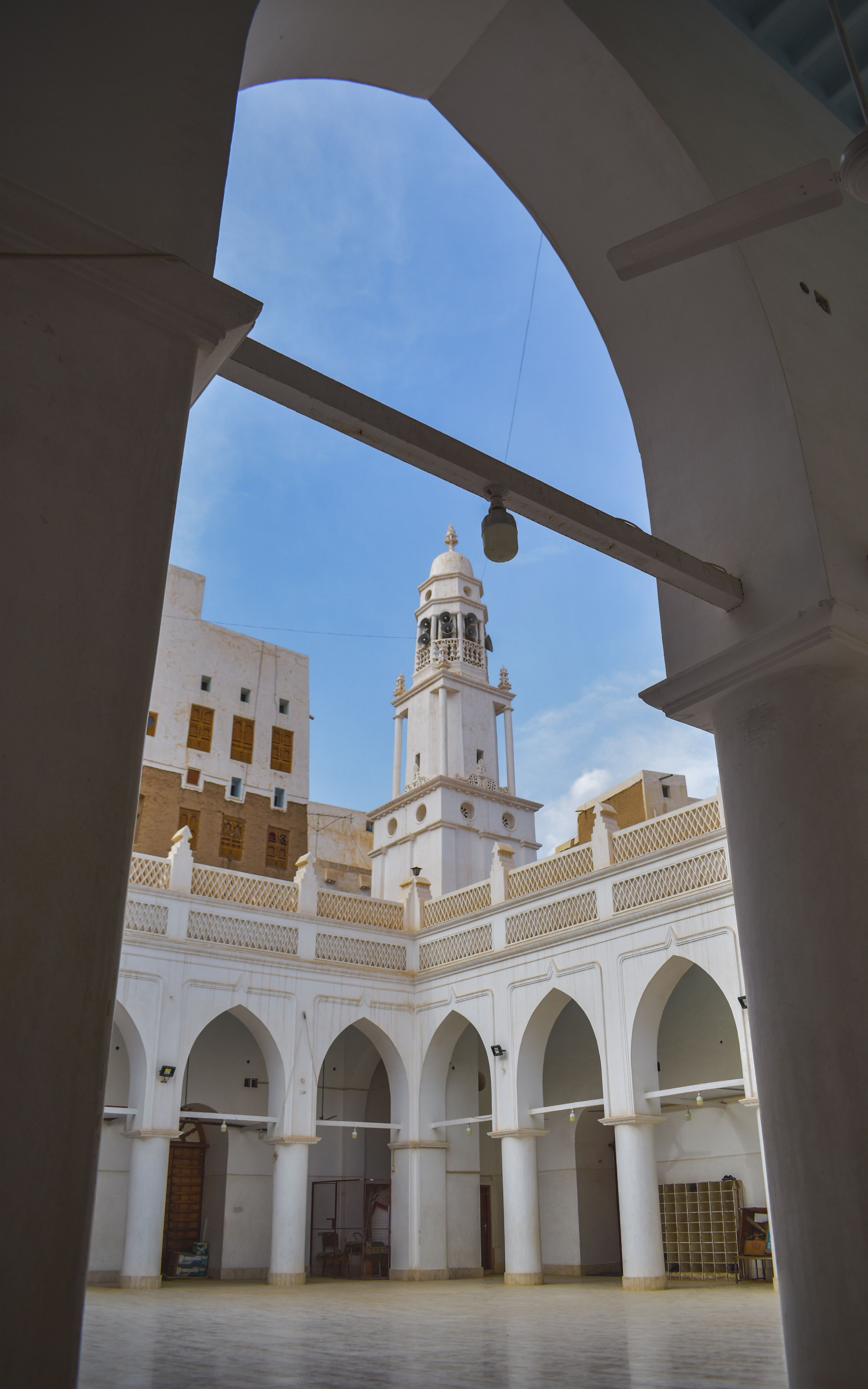 Historic mosque courtyard with arches and a tall minaret