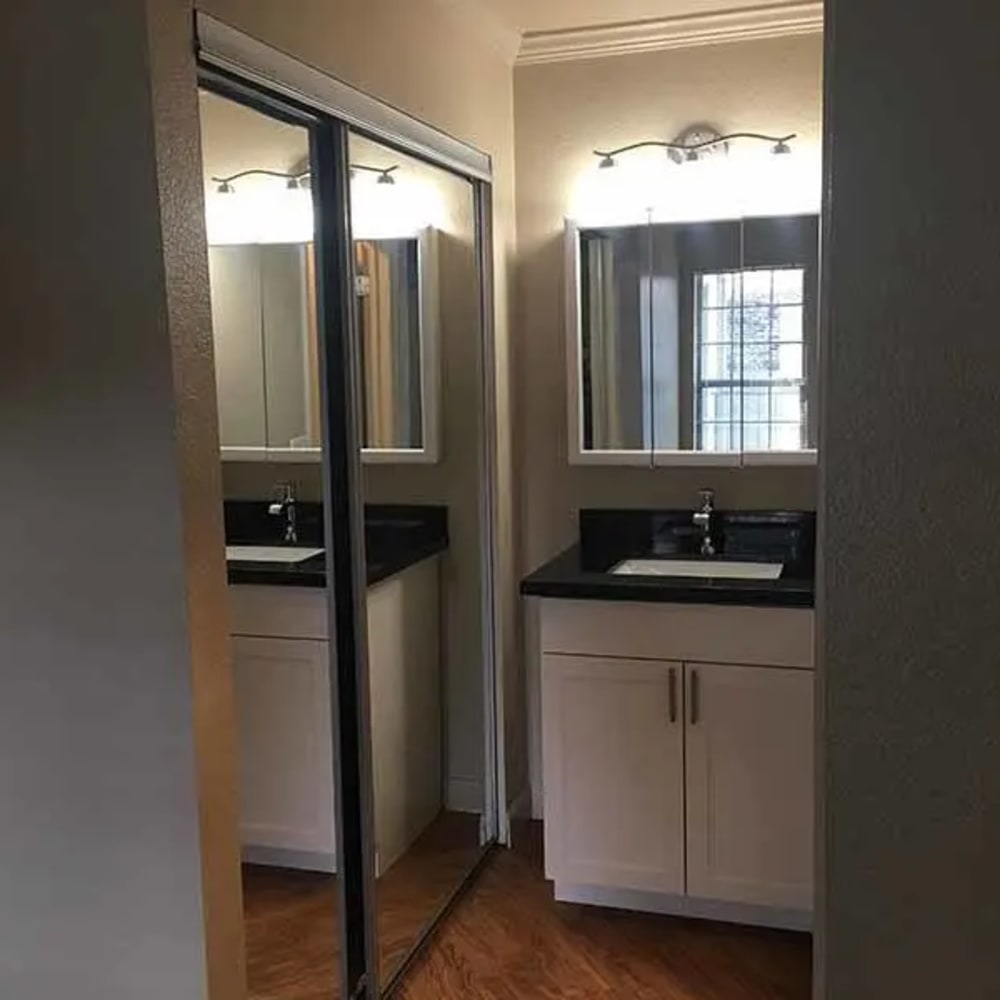 Bathroom with mirrored door closet and vanity with mirror