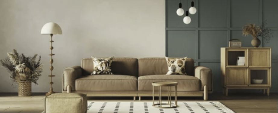 Beautifully decorated room with brown sofa, small coffee table, large lamp, plant and shelves.