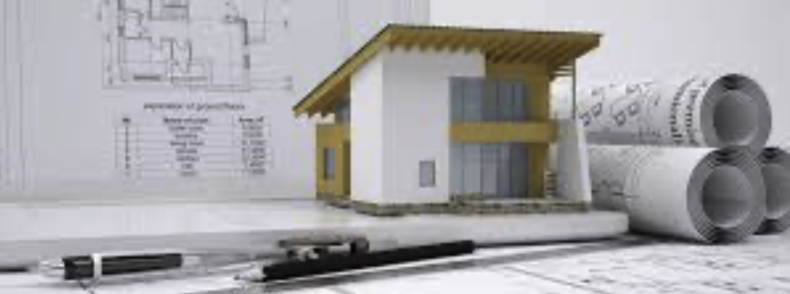 A mock-up of a house with drawings and a couple of rolled up drawings, illustrating architectural work in progress.