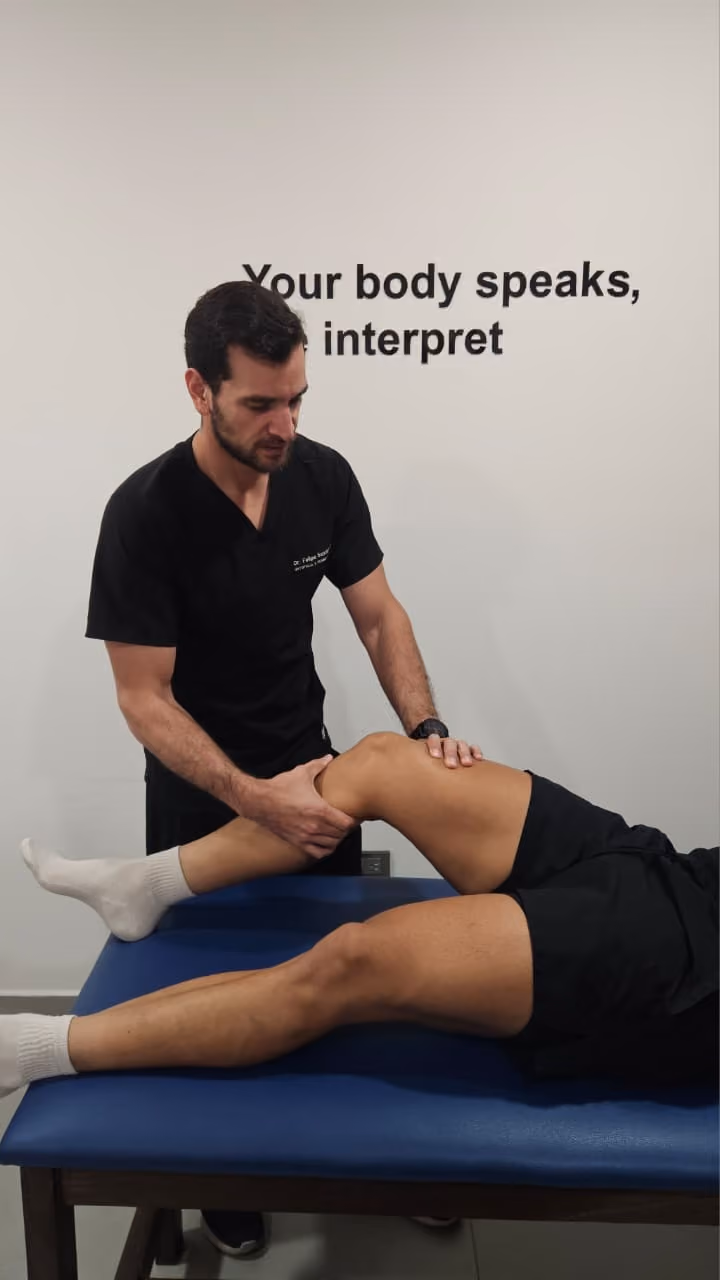Fisioterapeuta examinando la pierna de un paciente recostado en camilla azul.