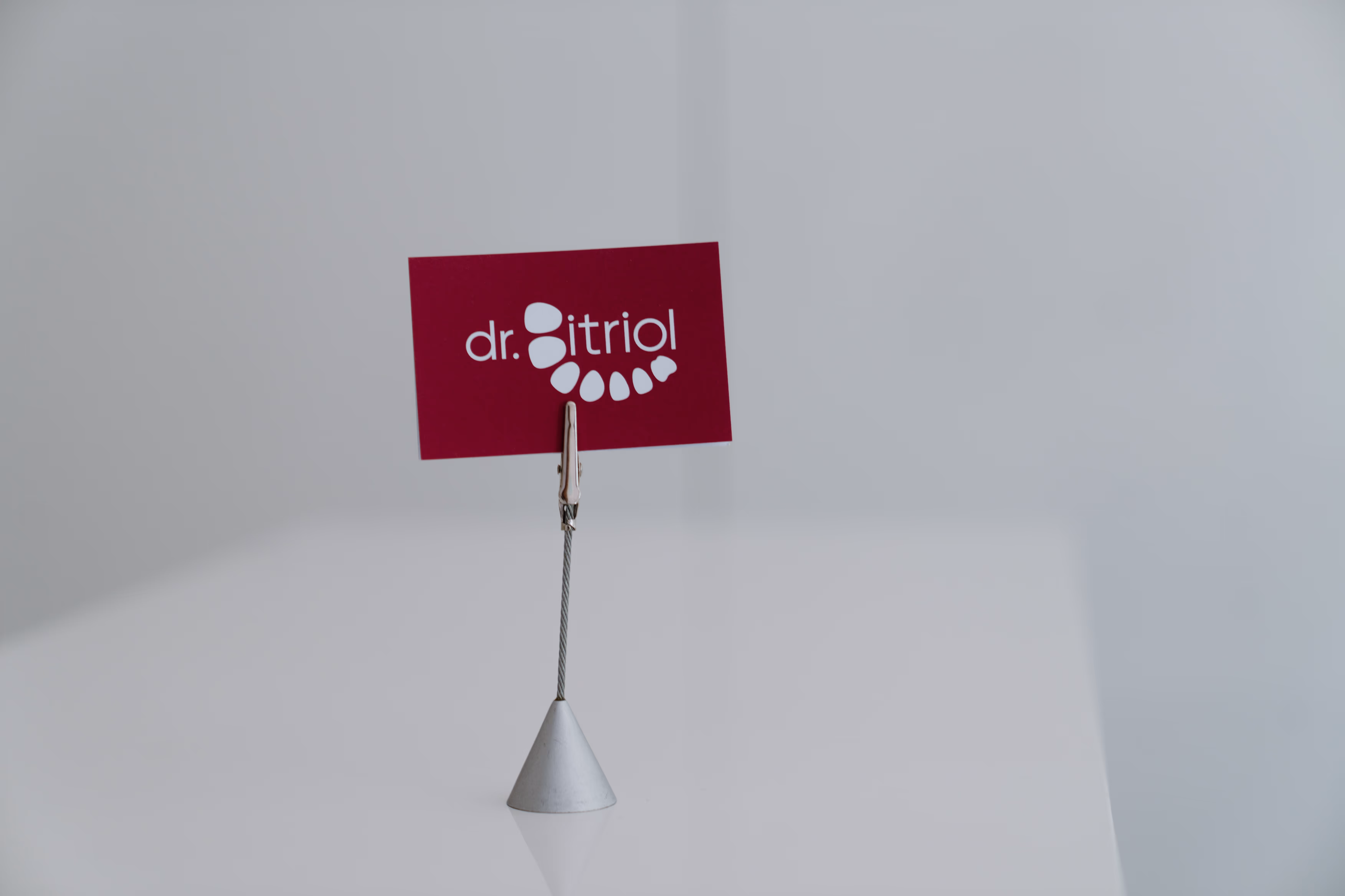 Karte mit dem weißen Text dr. bitriol und Zahnillustrationen auf rotem Hintergrund auf weißem Tisch.