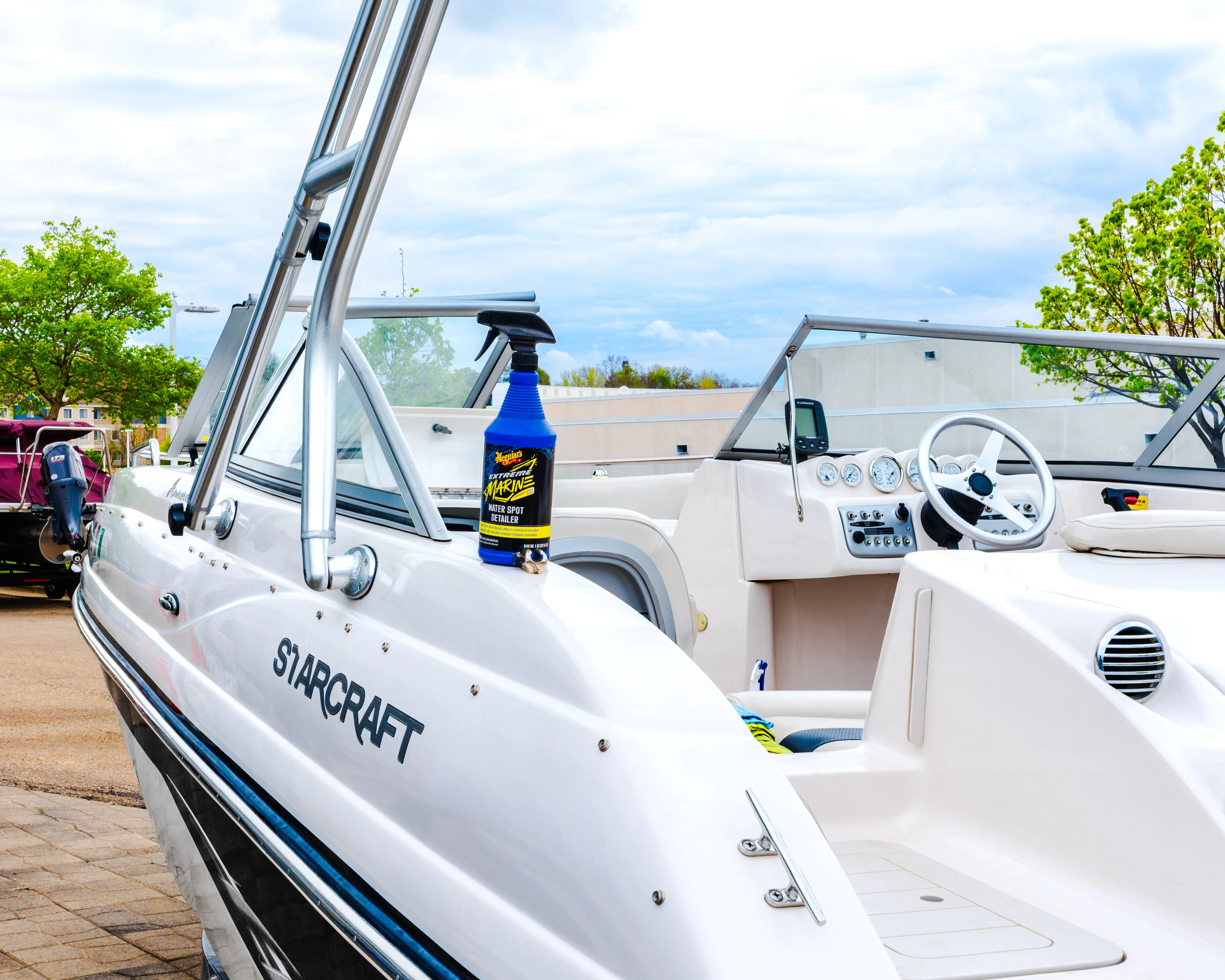 White Starcraft boat with a blue spray bottle of Meguiar's Marine Water Spot Detailer on its side.