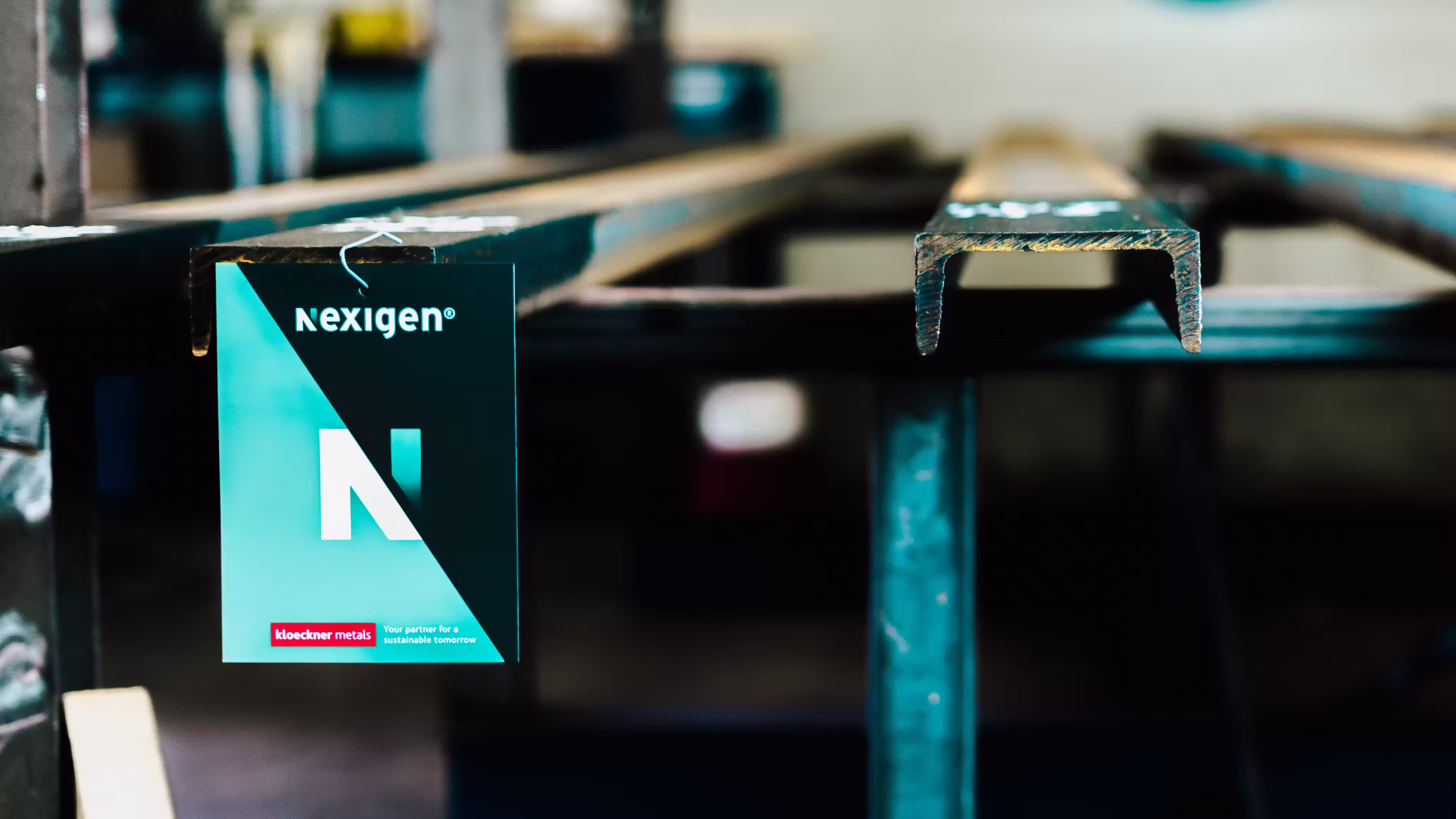 Nexigen branded hang-tag on a steel profile in a workshop
