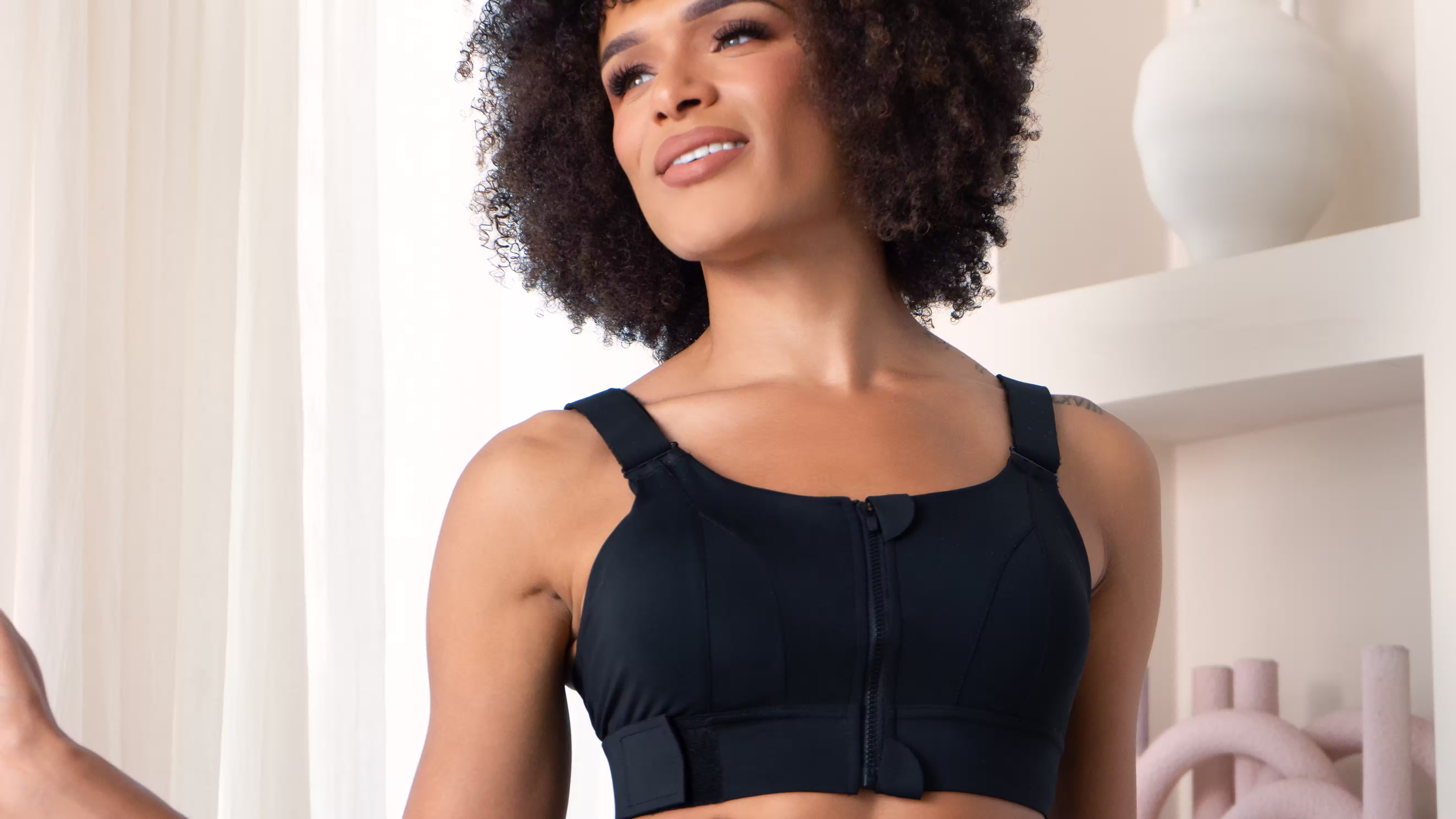 Smiling woman wearing a black Essie front-zip compression bra