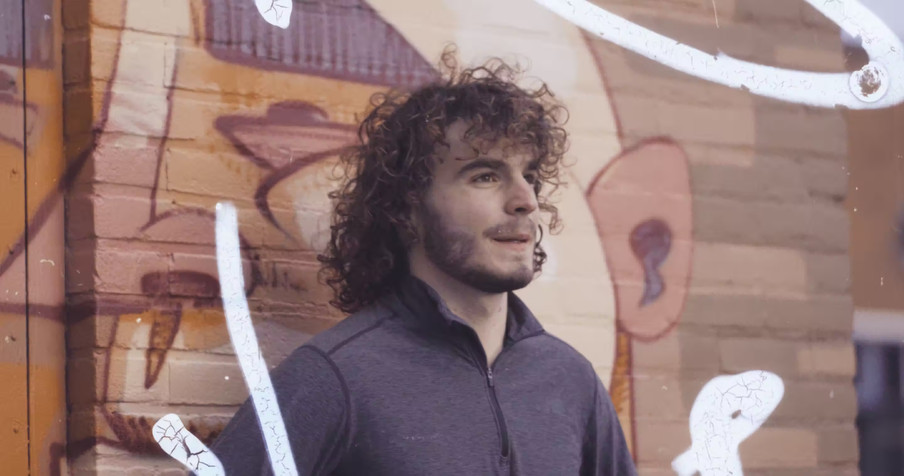 Man in athletic wear in front of a graffiti wall, Allblazing campaign