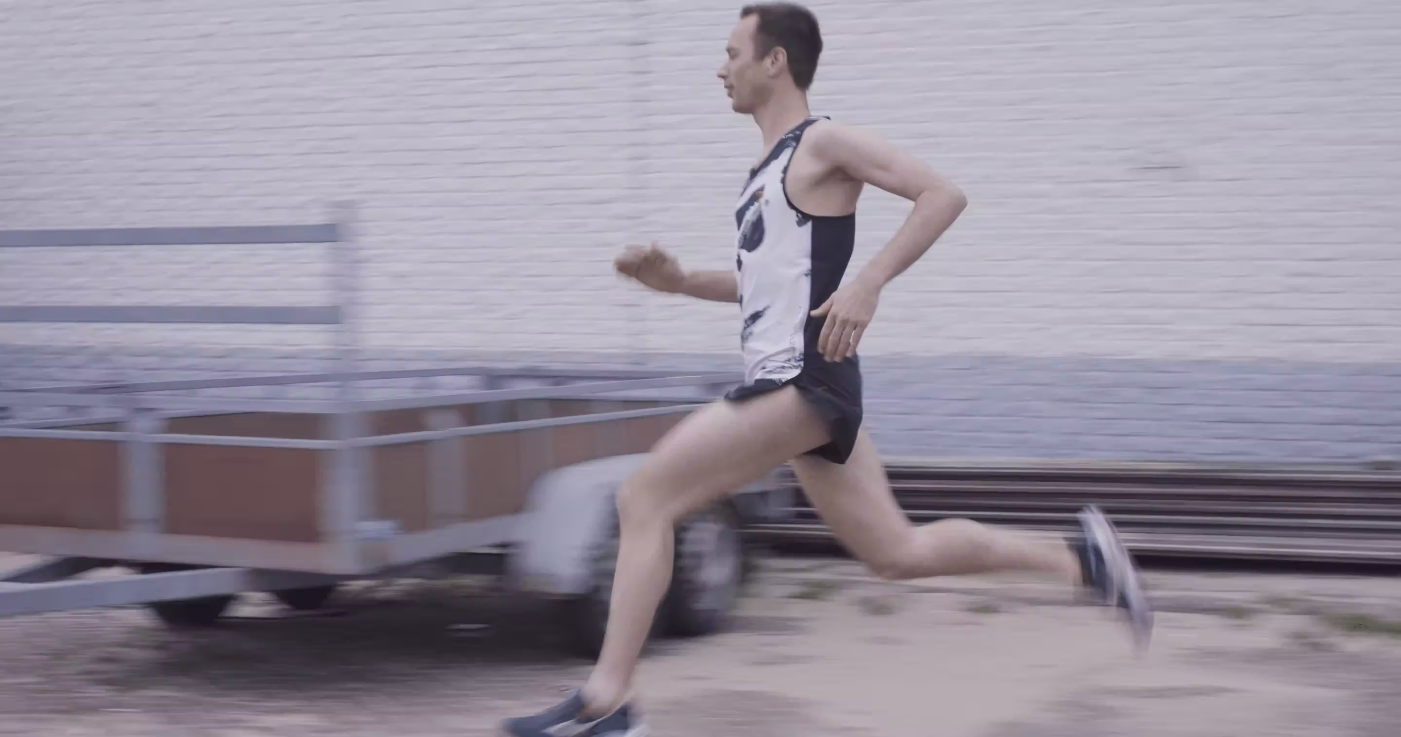 Runner sprinting past a brick wall, Allblazing campaign