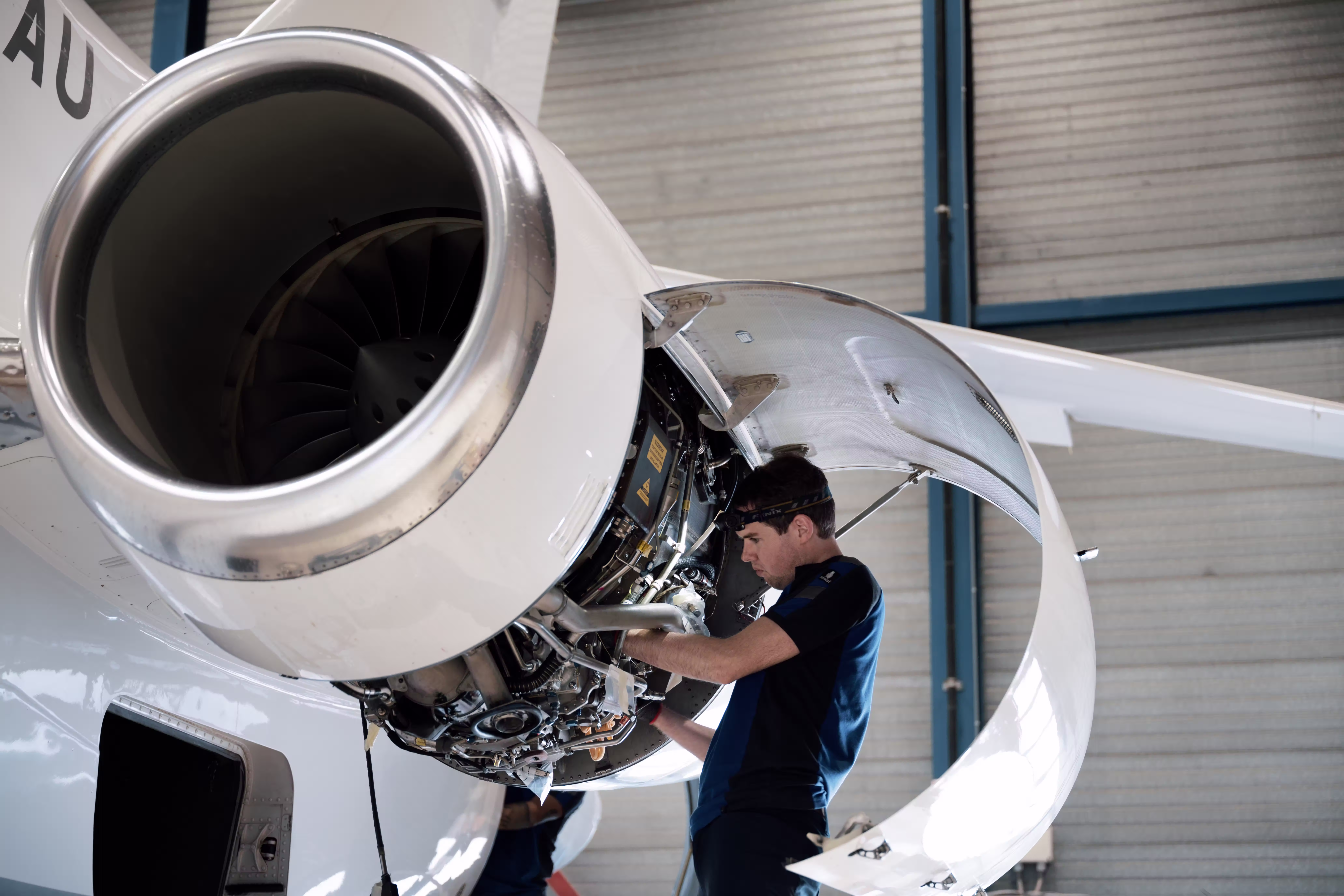 Technician servicing a business jet engine in a hangar