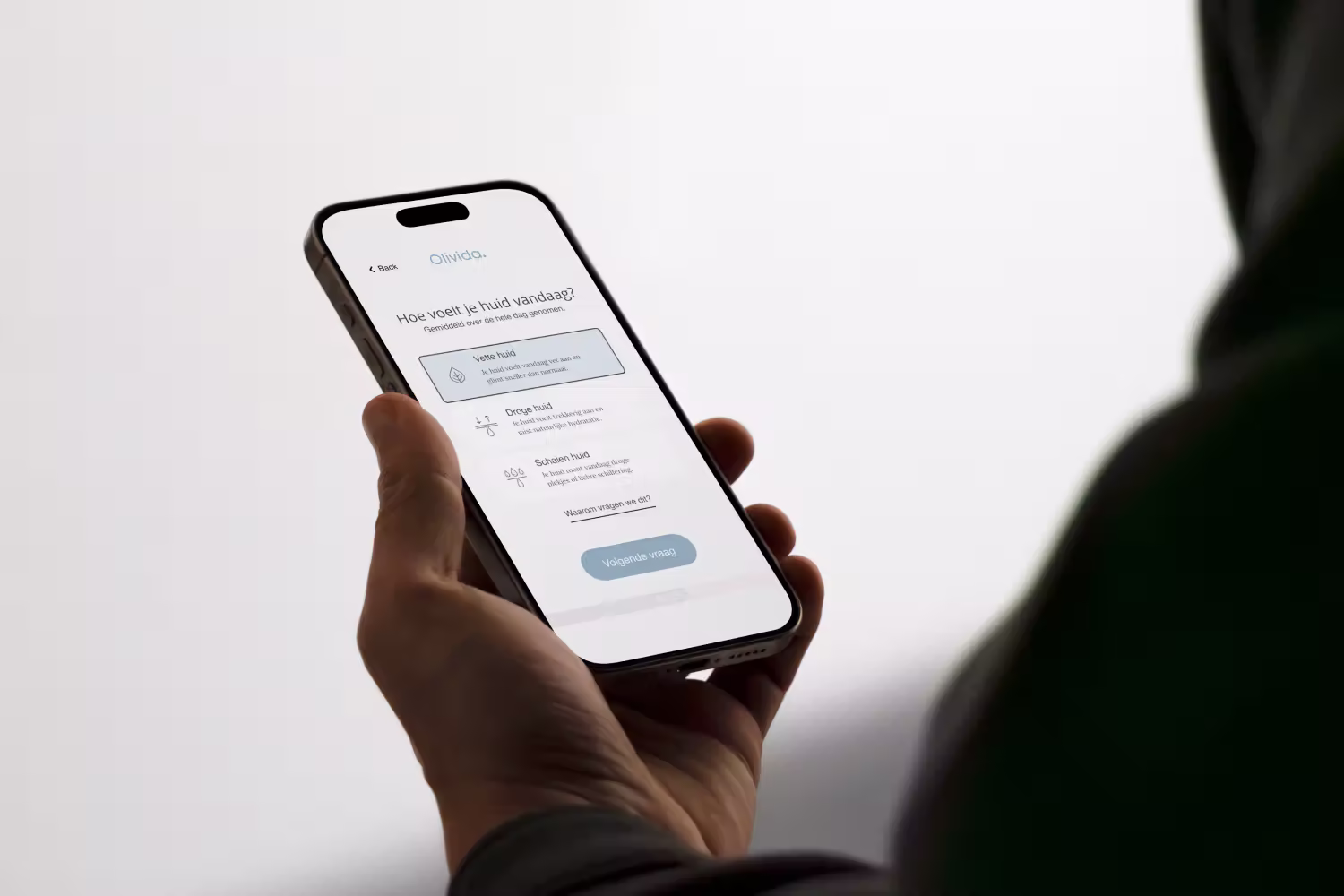 Hand holding a phone showing the Olivida skincare quiz
