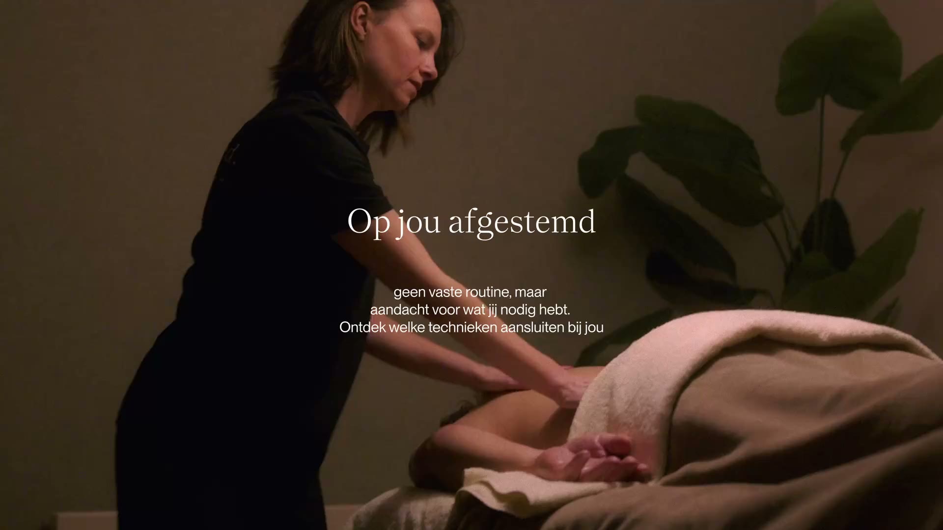 Massage therapist at work in a dimly lit Studio Release treatment room