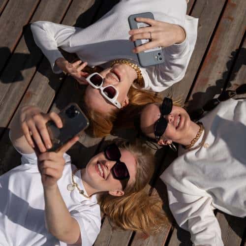 Influencer friends lying down taking selfies