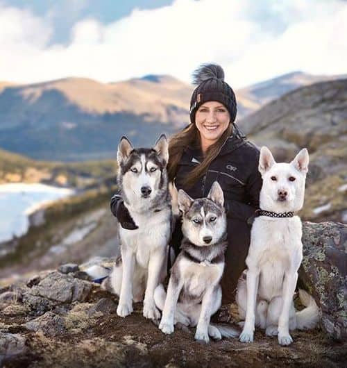 Katlin Longfield and her pet huskies on top of a mountain
