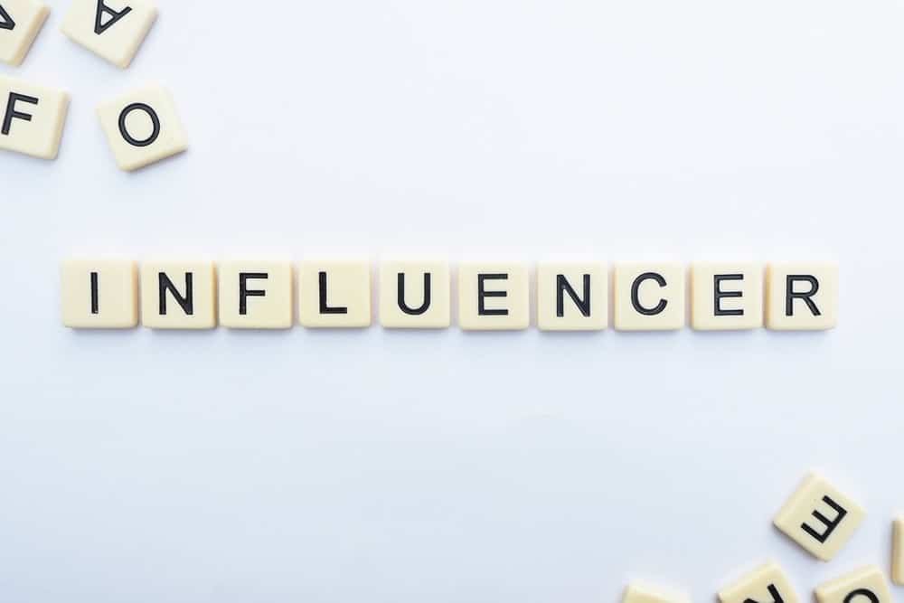 scrabble pieces spell the word INFLUENCER