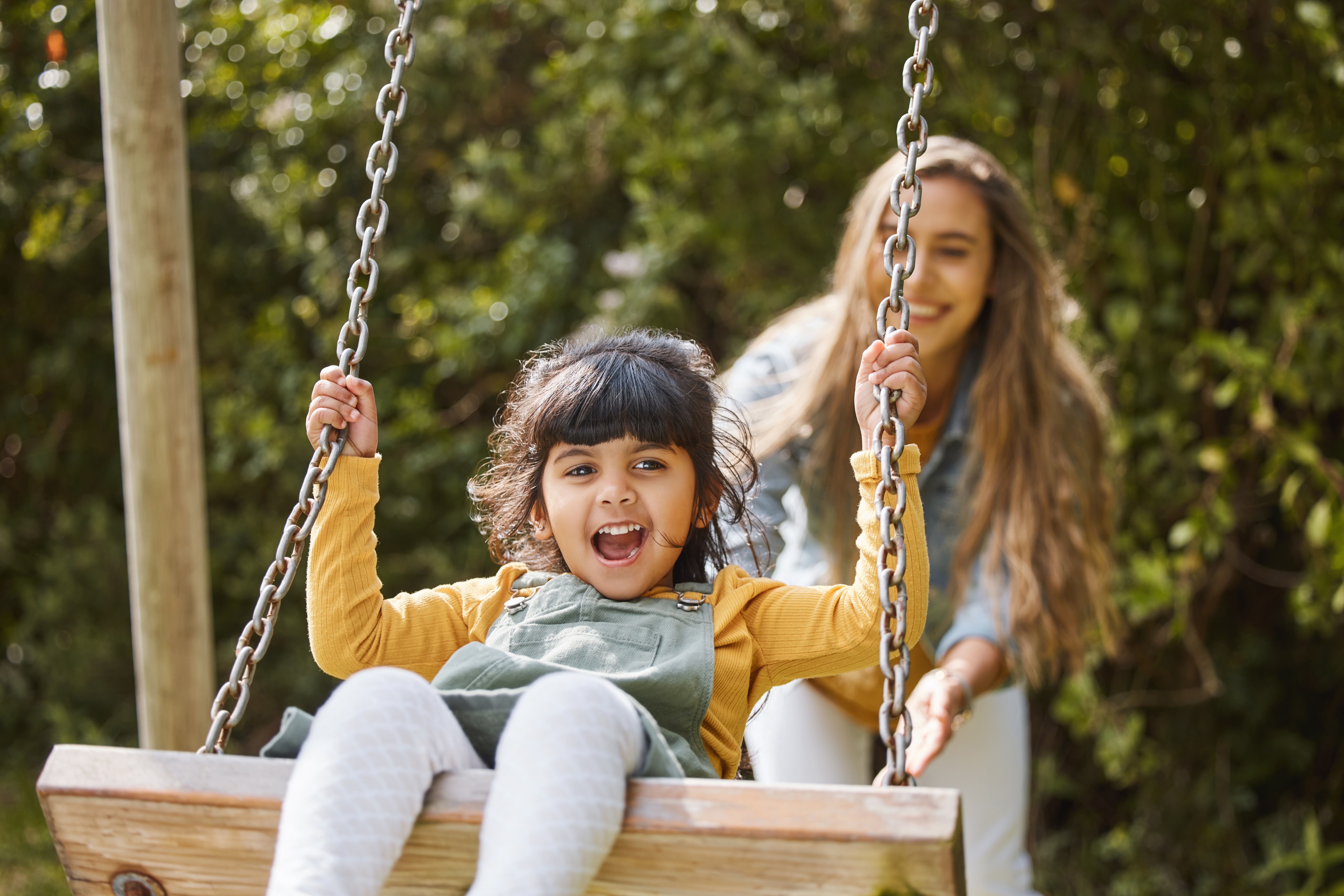 Woman pushing child on the swing stock image