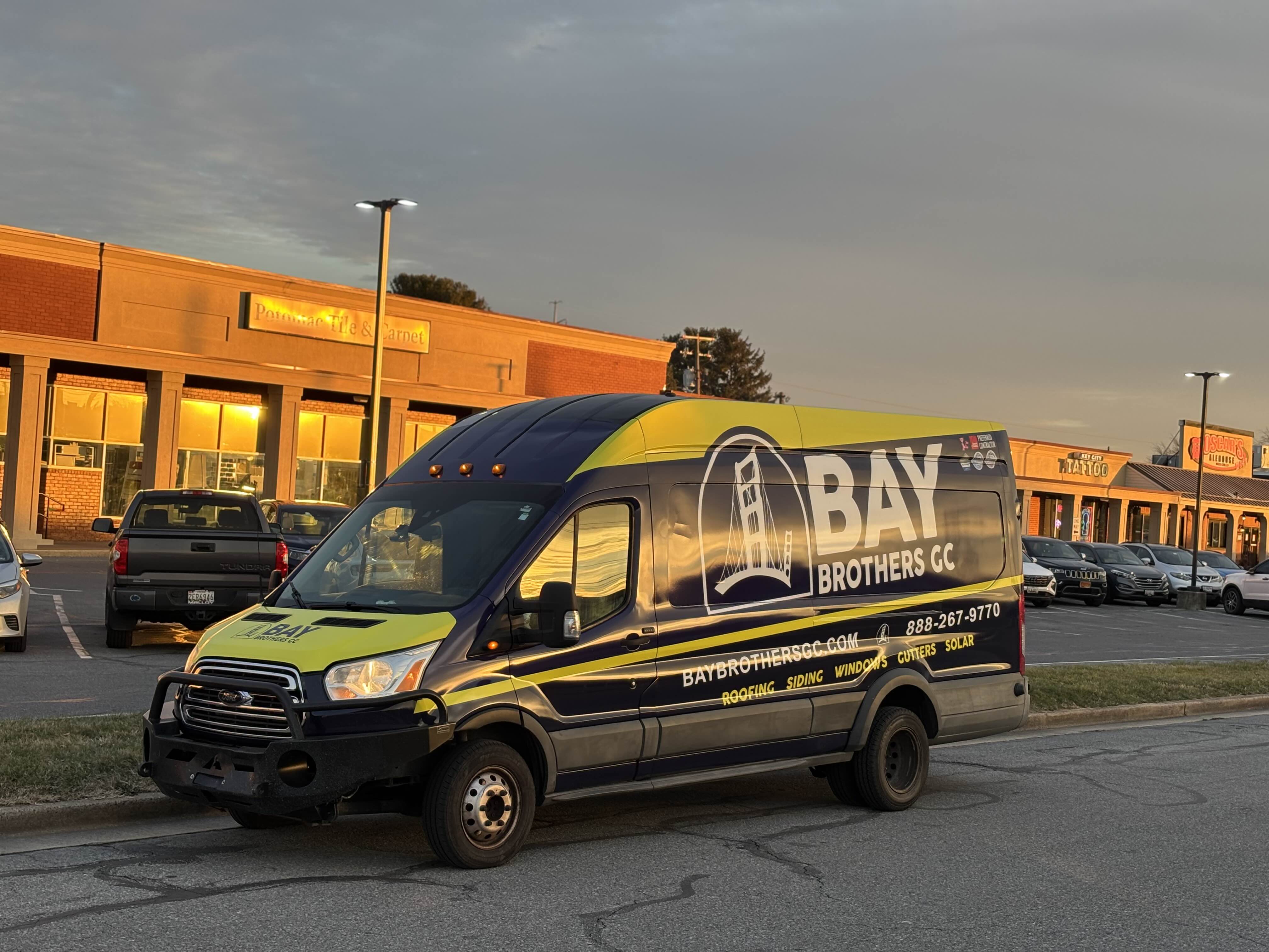Bay Brothers GC service van wrapped with company branding, parked outside Frederick Maryland office