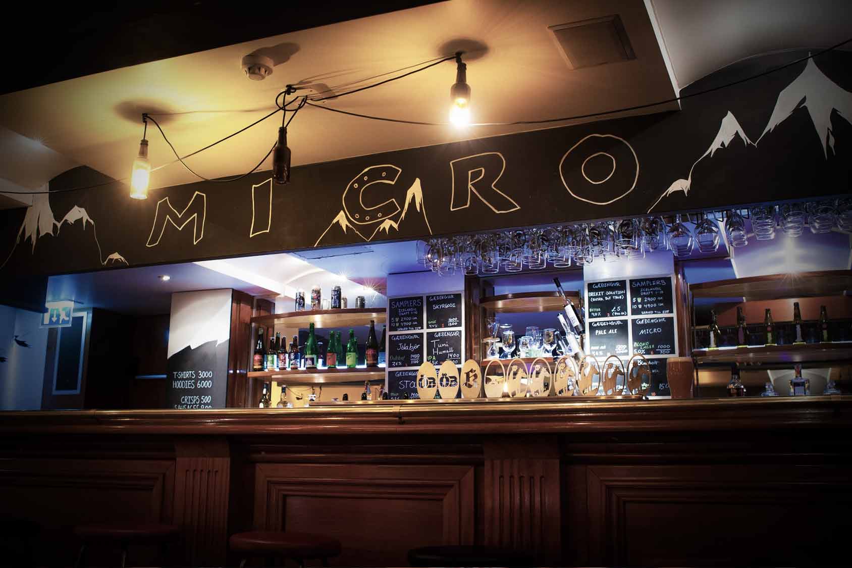 Micro Bar in Reykjavik, a craft beer bar with a minimalist aesthetic, featuring a wide selection of local and international beers displayed on a chalkboard menu.
