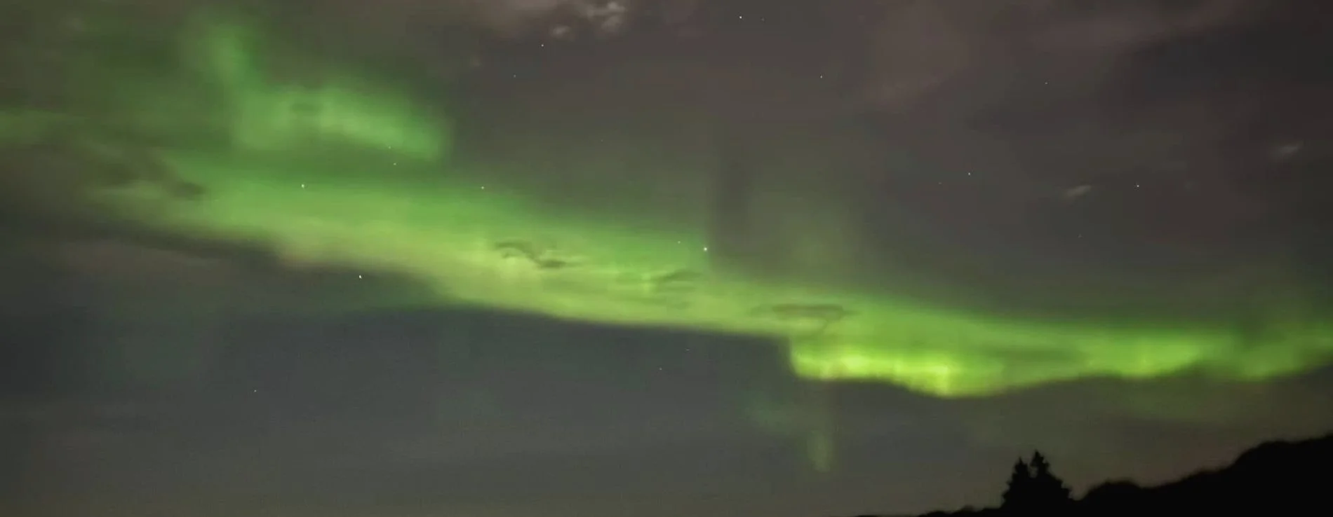 Northern Lights in green nearby Borgarnes town in Iceland.