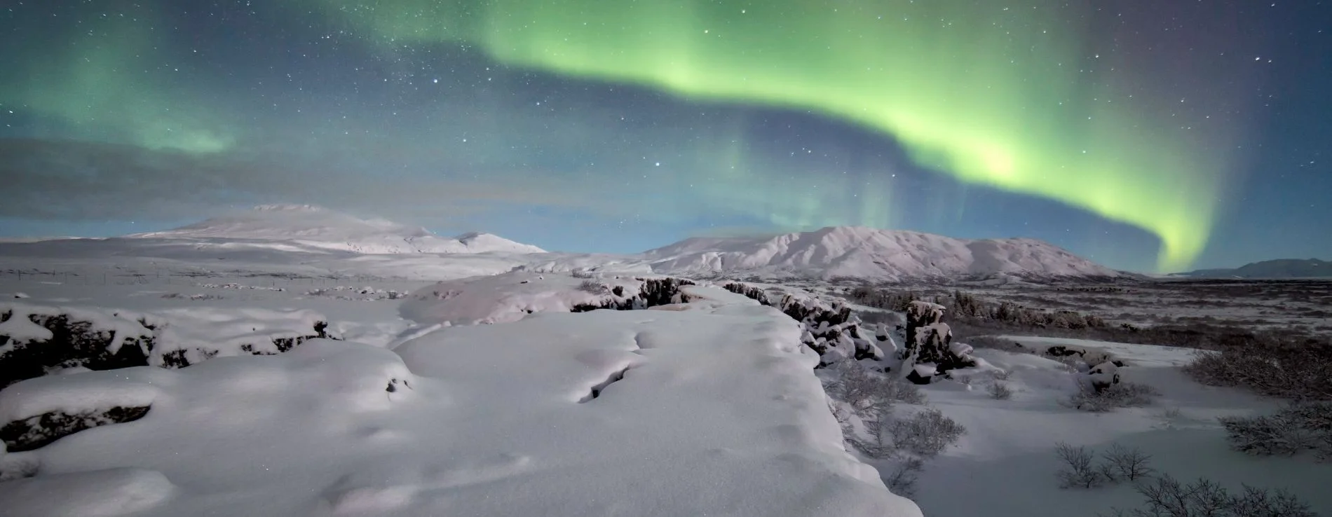 Iceland's Golden Circle during Northern Lights sighting over snow covered ground at Thingvellir.
