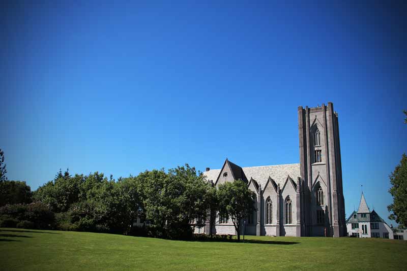 Landakotskirkja, also known as the Cathedral of Christ the King, a Gothic Revival church located in Reykjavík, Iceland, surrounded by greenery.