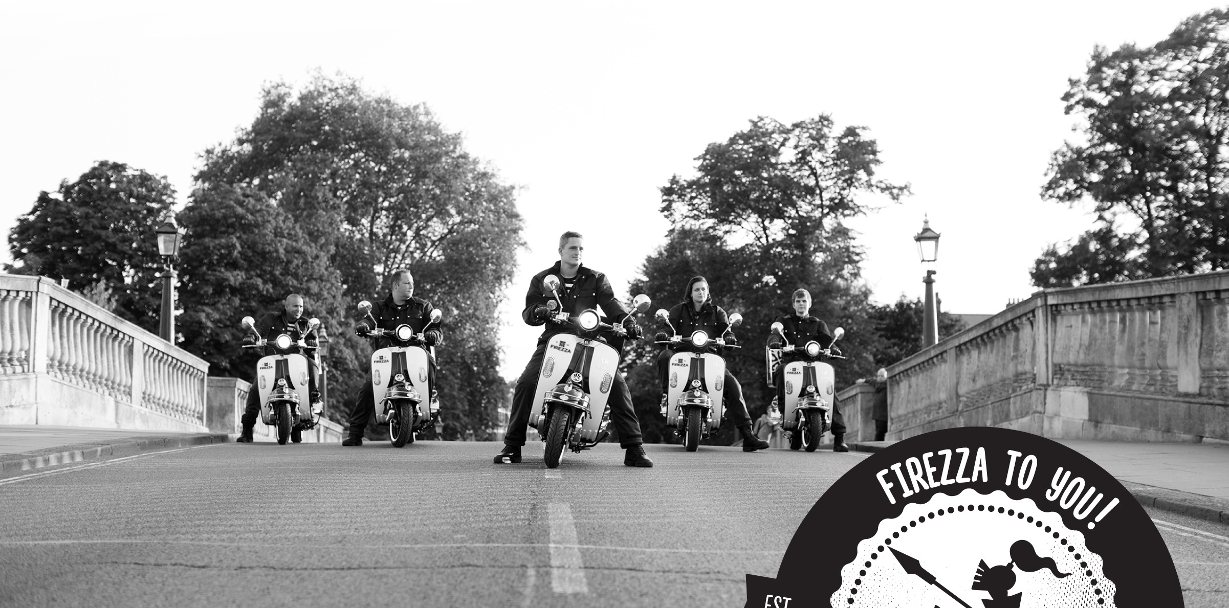 A black and white photo of a line of Firezza delivery riders on branded scooters on a bridge, with the Firezza to you badge