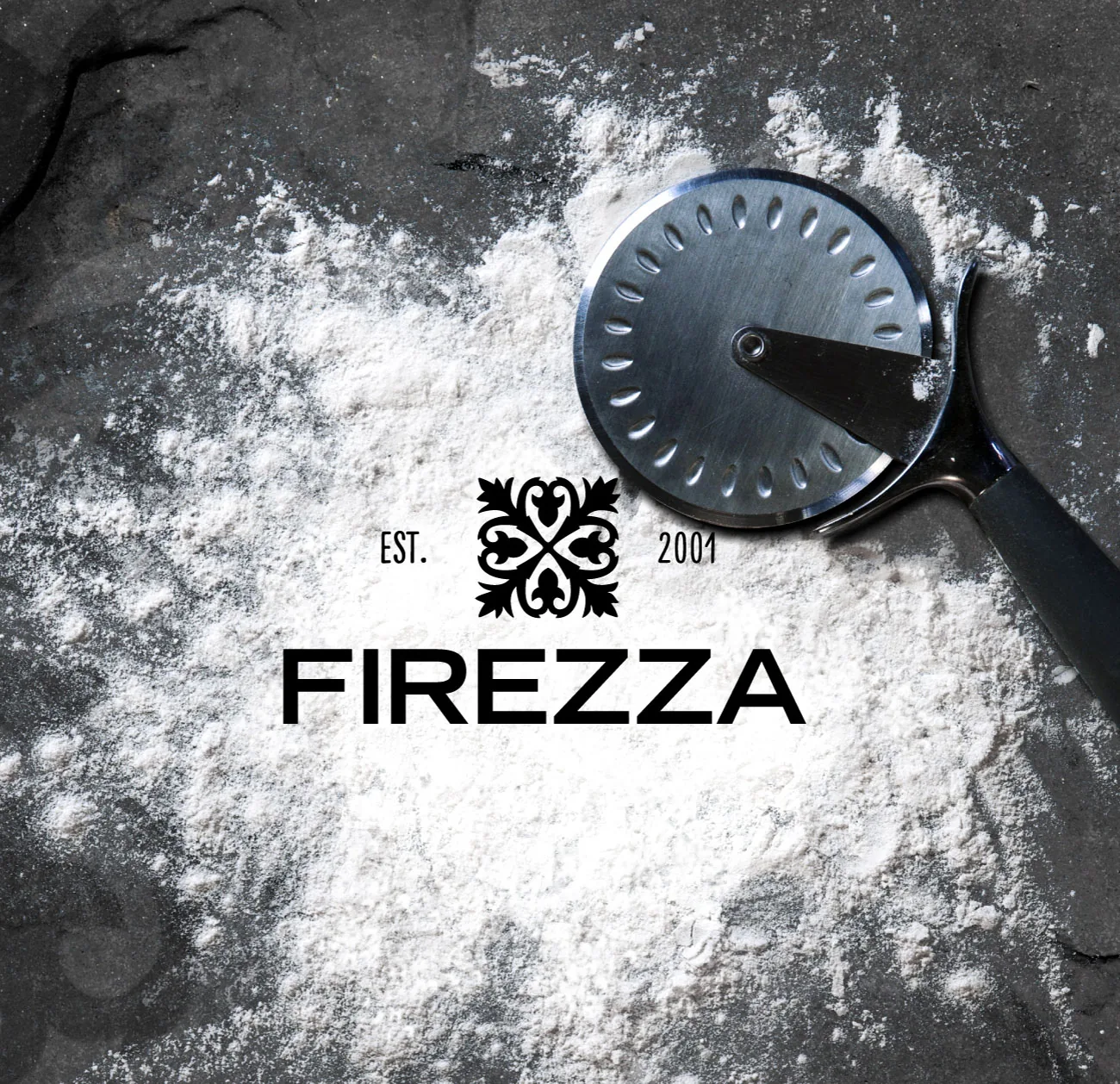 The Firezza logo printed on a floured surface beside a pizza cutter