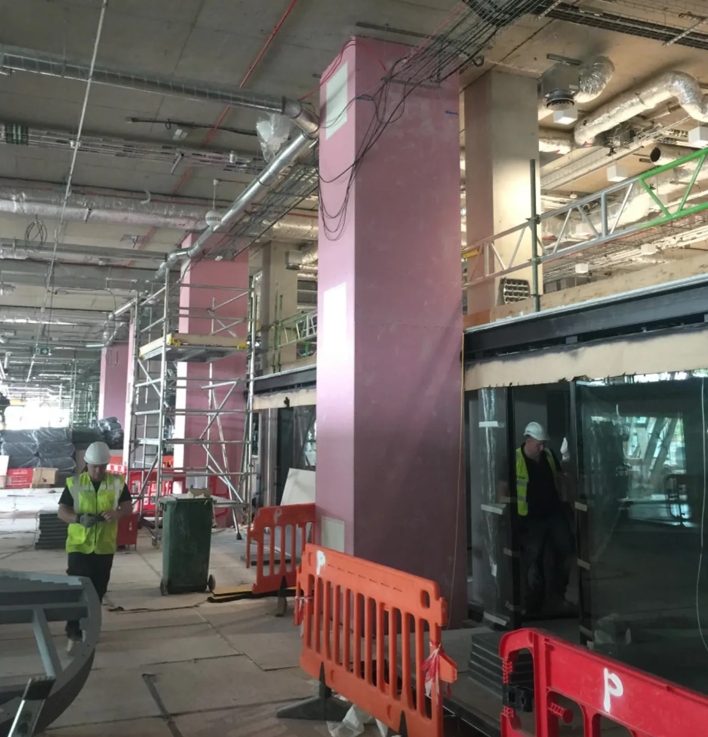 Builders in hi-vis jackets on site inside Here East during Plexal’s construction