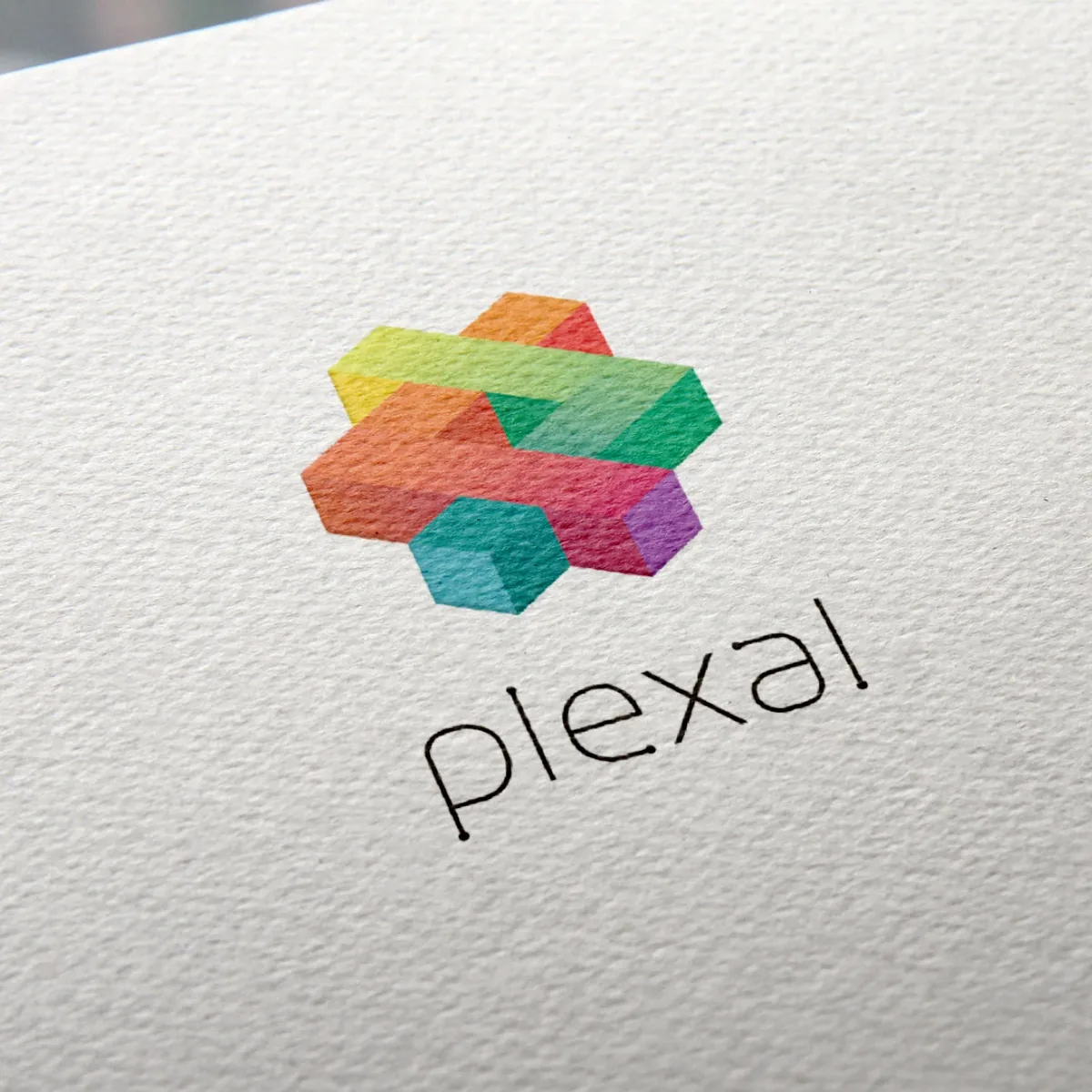 The multicoloured Plexal logo and wordmark printed on textured white paper