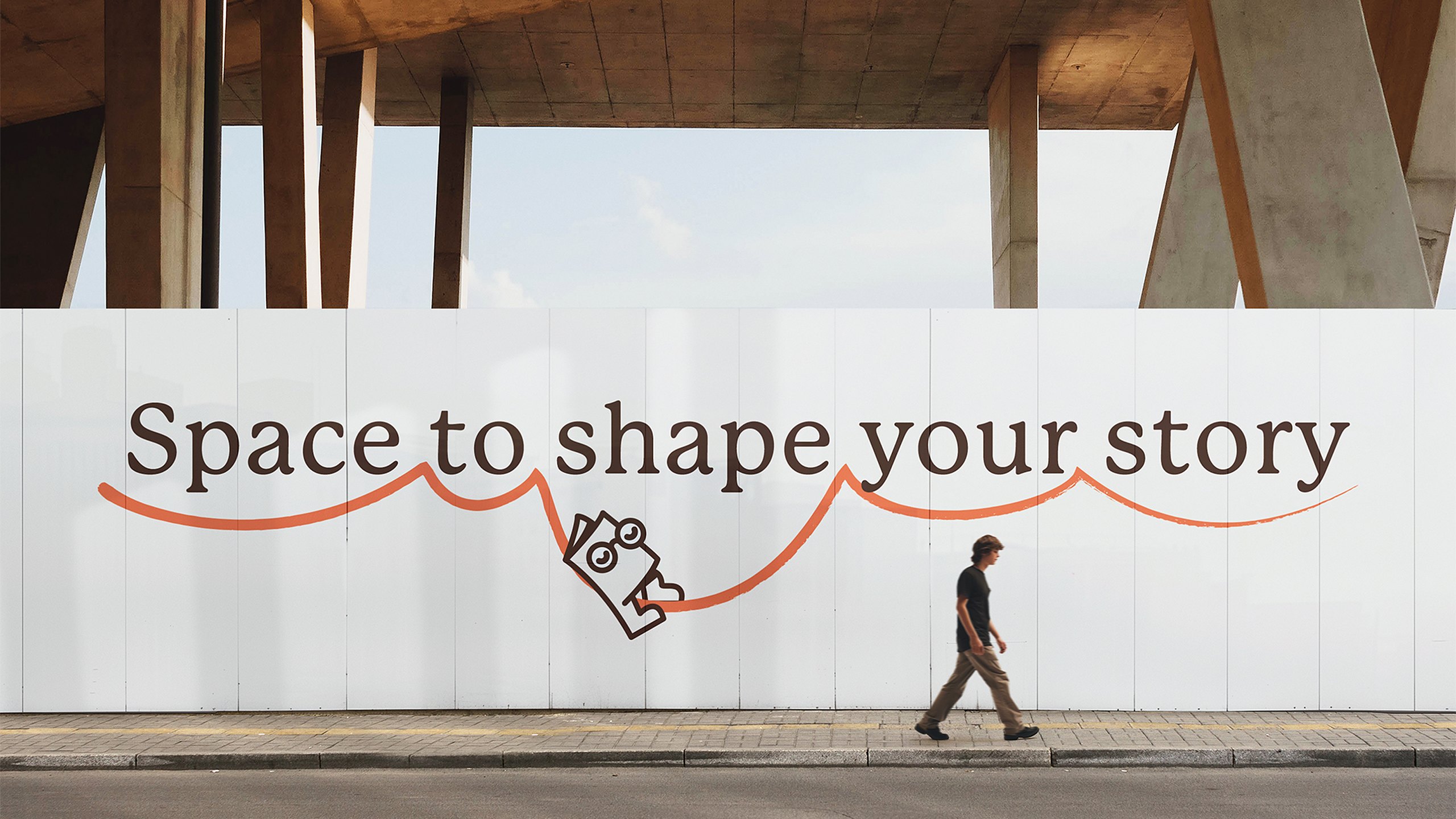 A white hoarding under a concrete canopy printed with the Libraro line Space to shape your story, with the Libro mascot riding a looping orange line as a man walks past