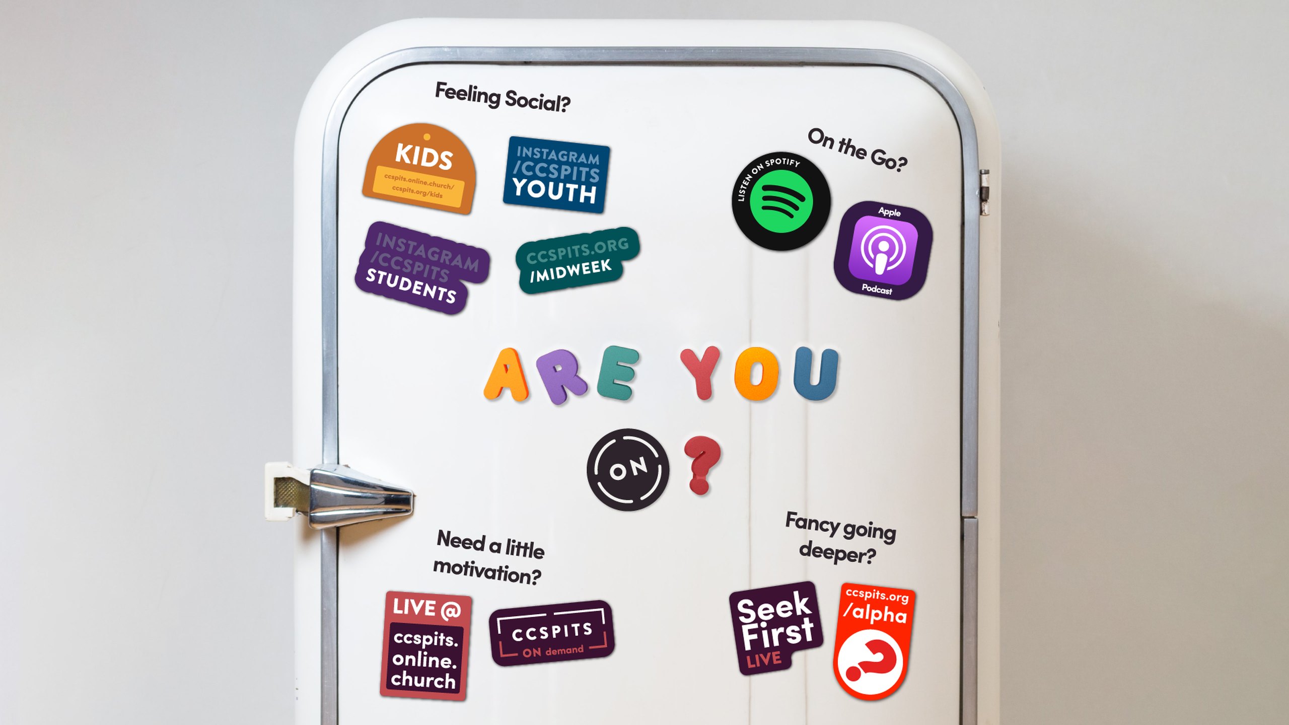 A white retro fridge covered in CCSPITS stickers and magnets asking Are you ON?, with stickers for Kids, Youth, Students, Midweek, live services, on demand, Spotify and Apple podcasts, Seek First and Alpha