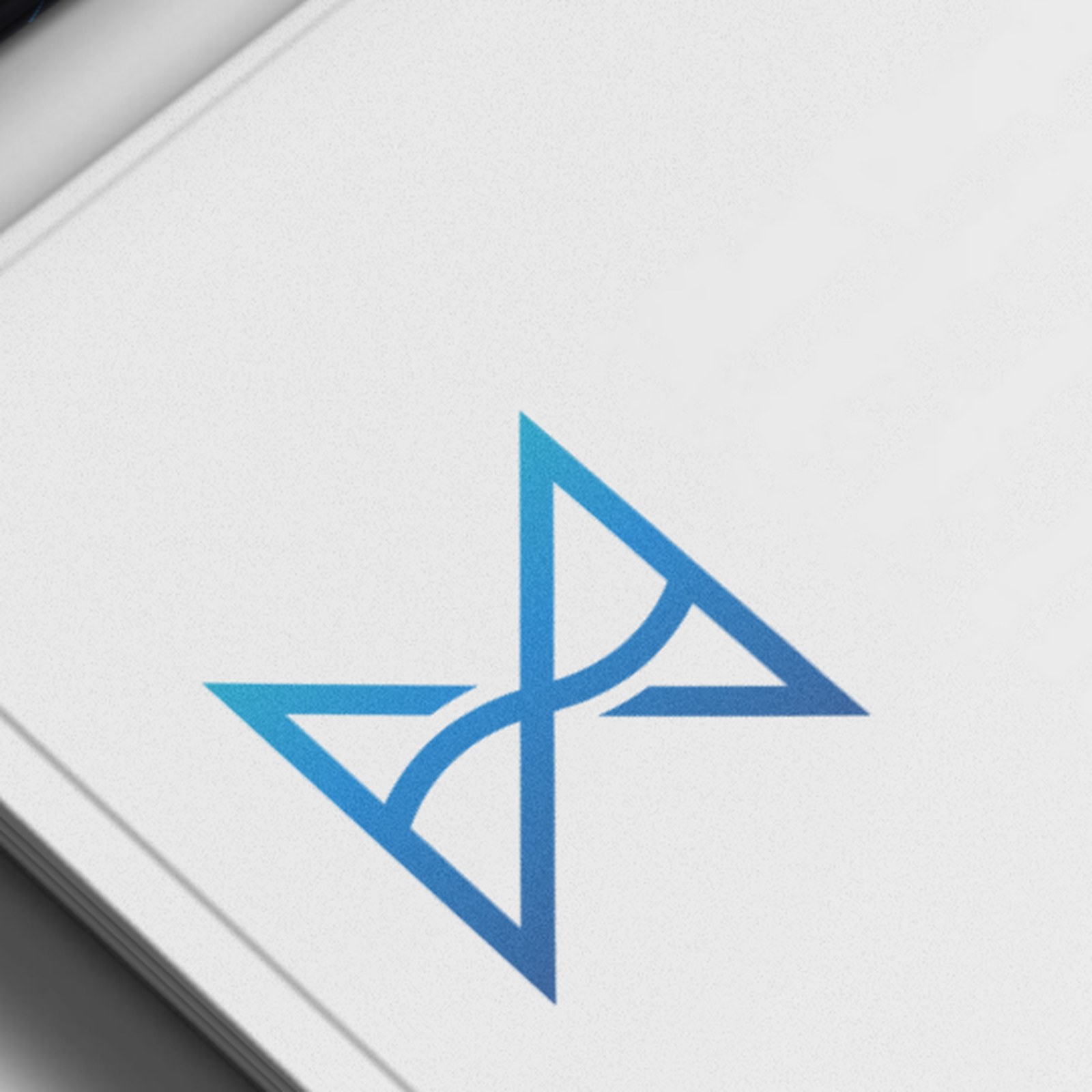 Close-up of the blue Deeplight symbol, two triangles meeting at a curved waist, printed on a white business card