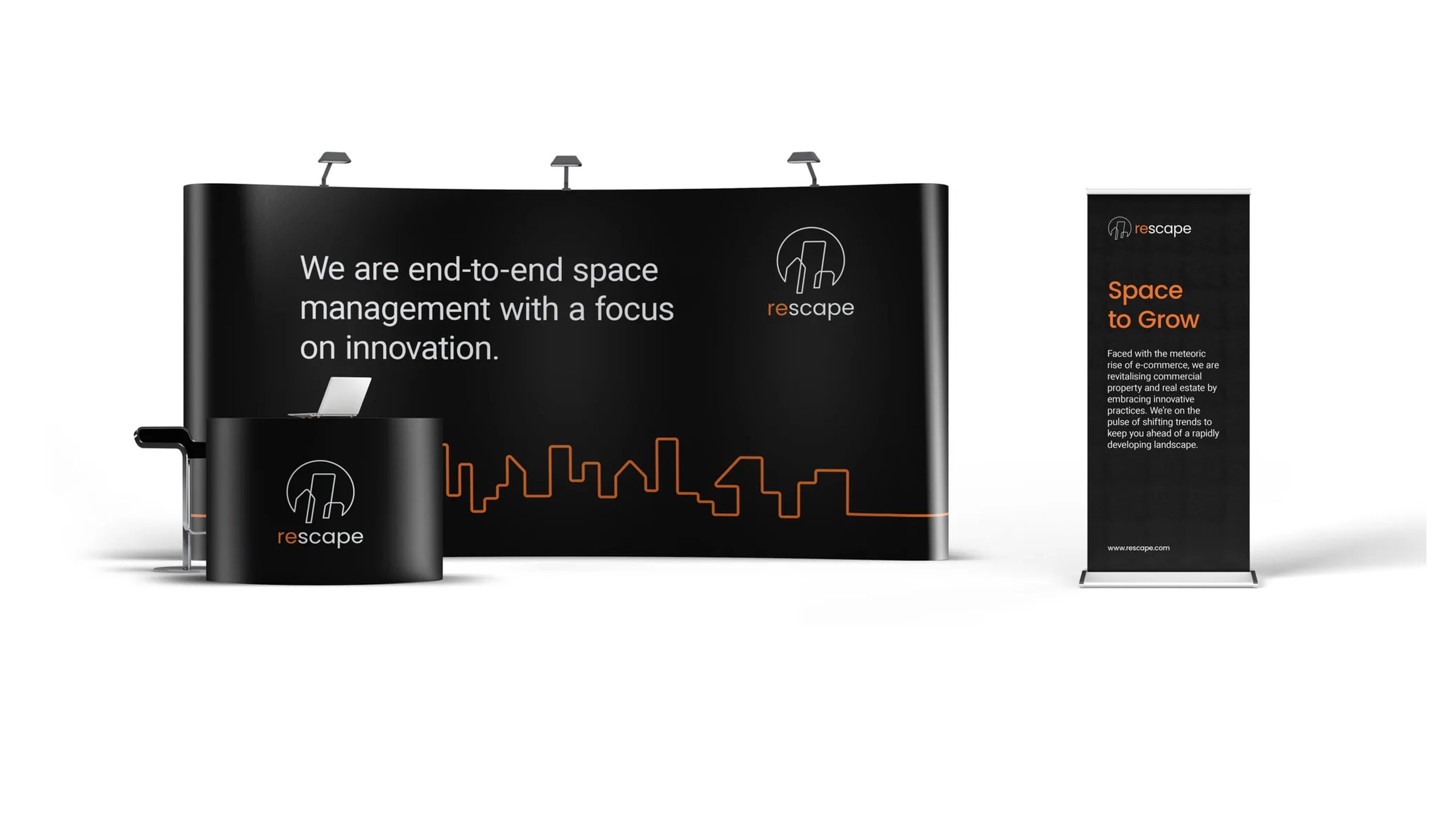 A Rescape exhibition stand in midnight black: a curved wall reading We are end-to-end space management with a focus on innovation above an orange skyline line, a branded counter and a Space to Grow roller banner
