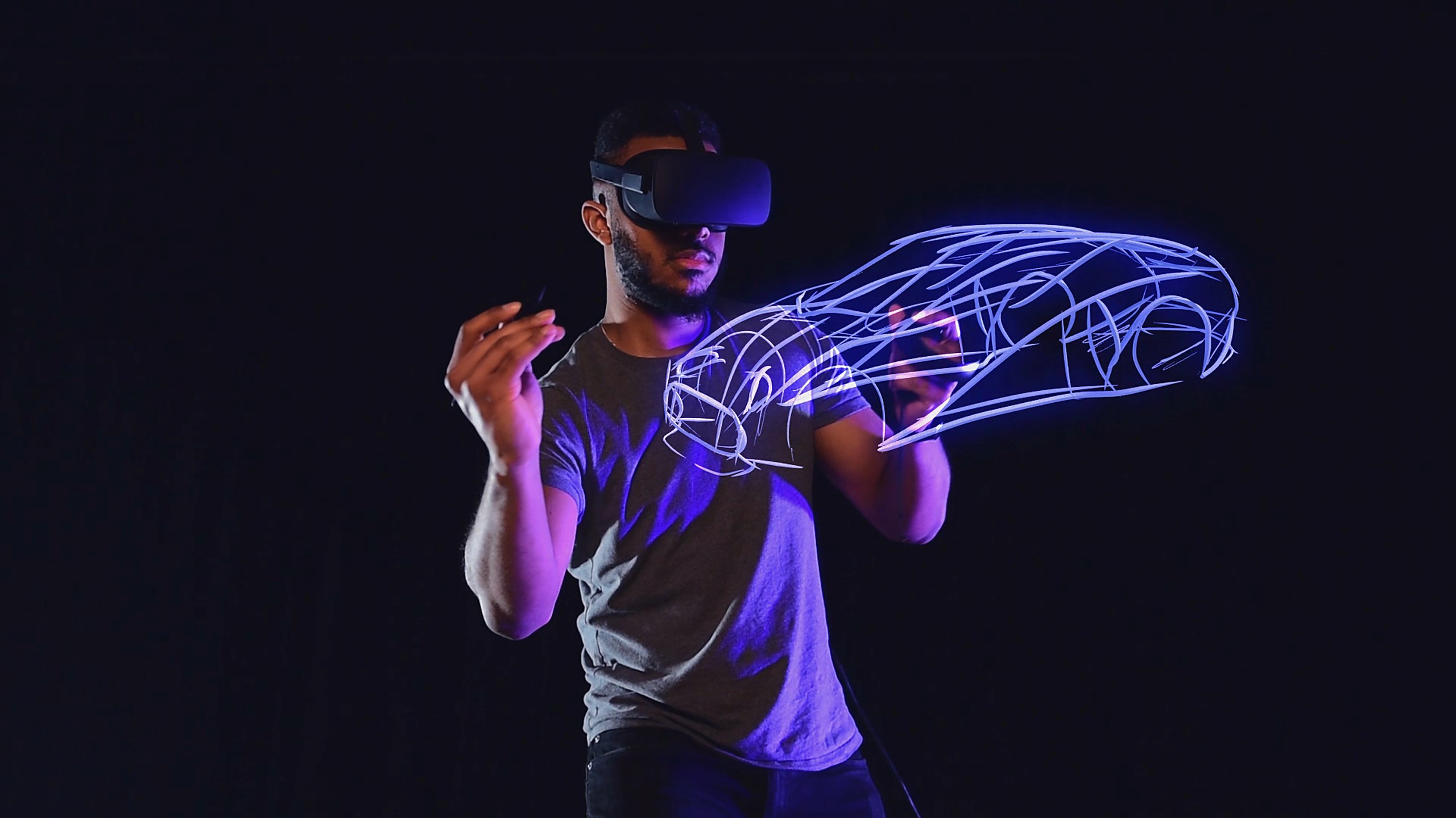 A still from Outfly’s Massless crowdfunding film: a designer in a VR headset sketching a glowing blue car in mid-air with the Massless Pen, against a black background