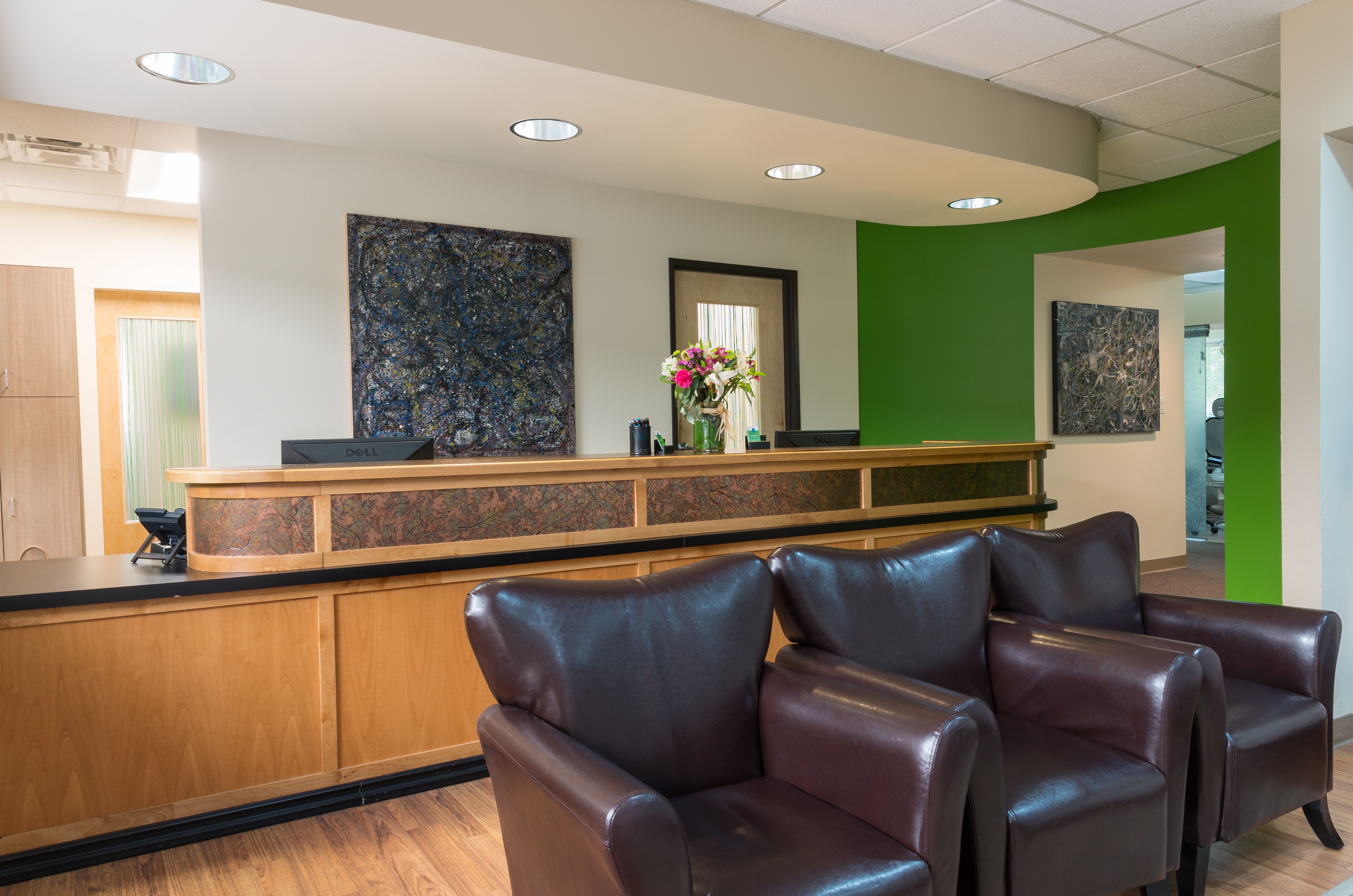 Front desk and reception area at Parkway Dental with wooden counter and comfortable lobby seating